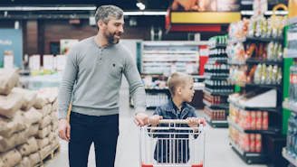 A father and son shop together in a supermarket.