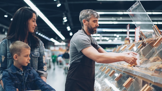 A family shops at a food display.