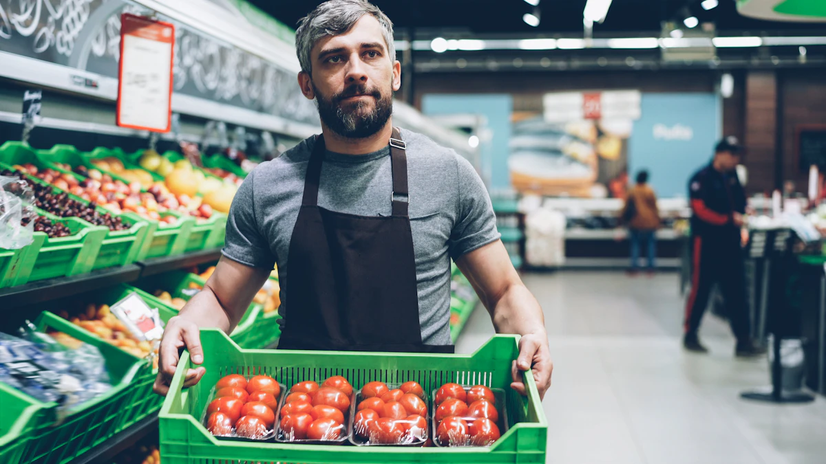 Employé de magasin portant une caisse de tomates dans un rayon de fruits et légumes