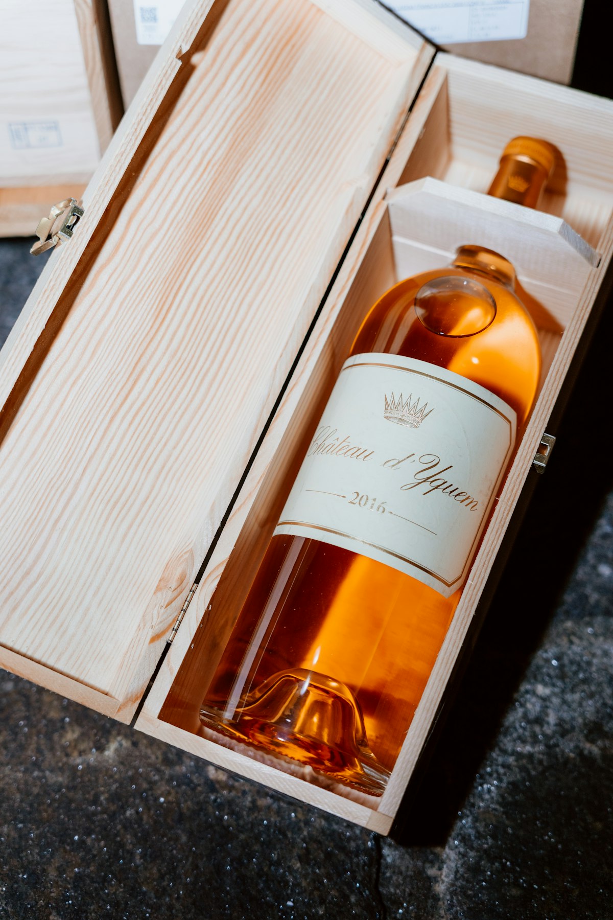 A single bottle of wine resting in an open wooden gift box