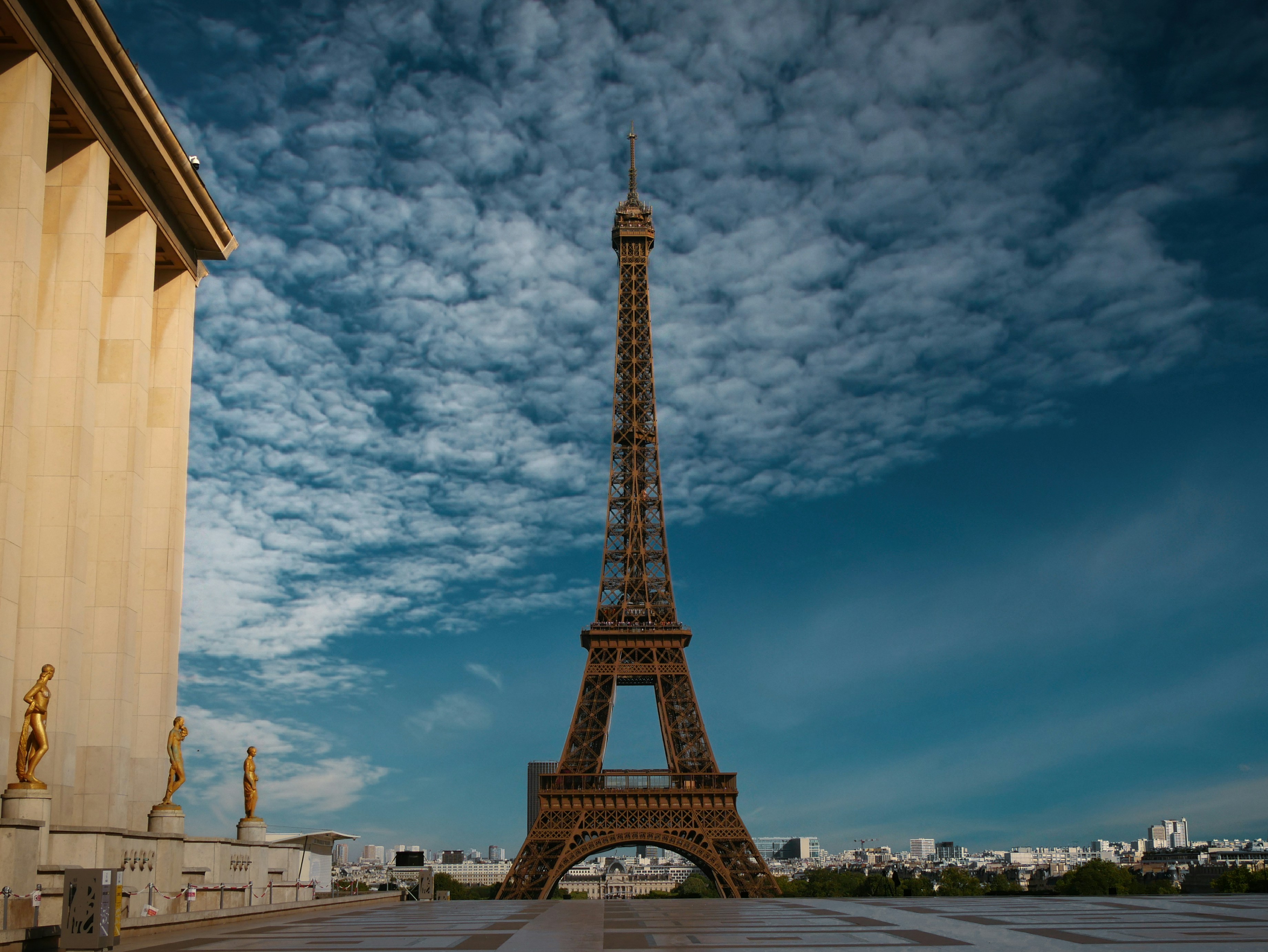 The eiffel tower stands tall against a cloudy sky.