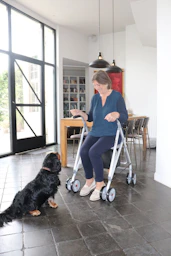 Woman with walker interacts with her dog.