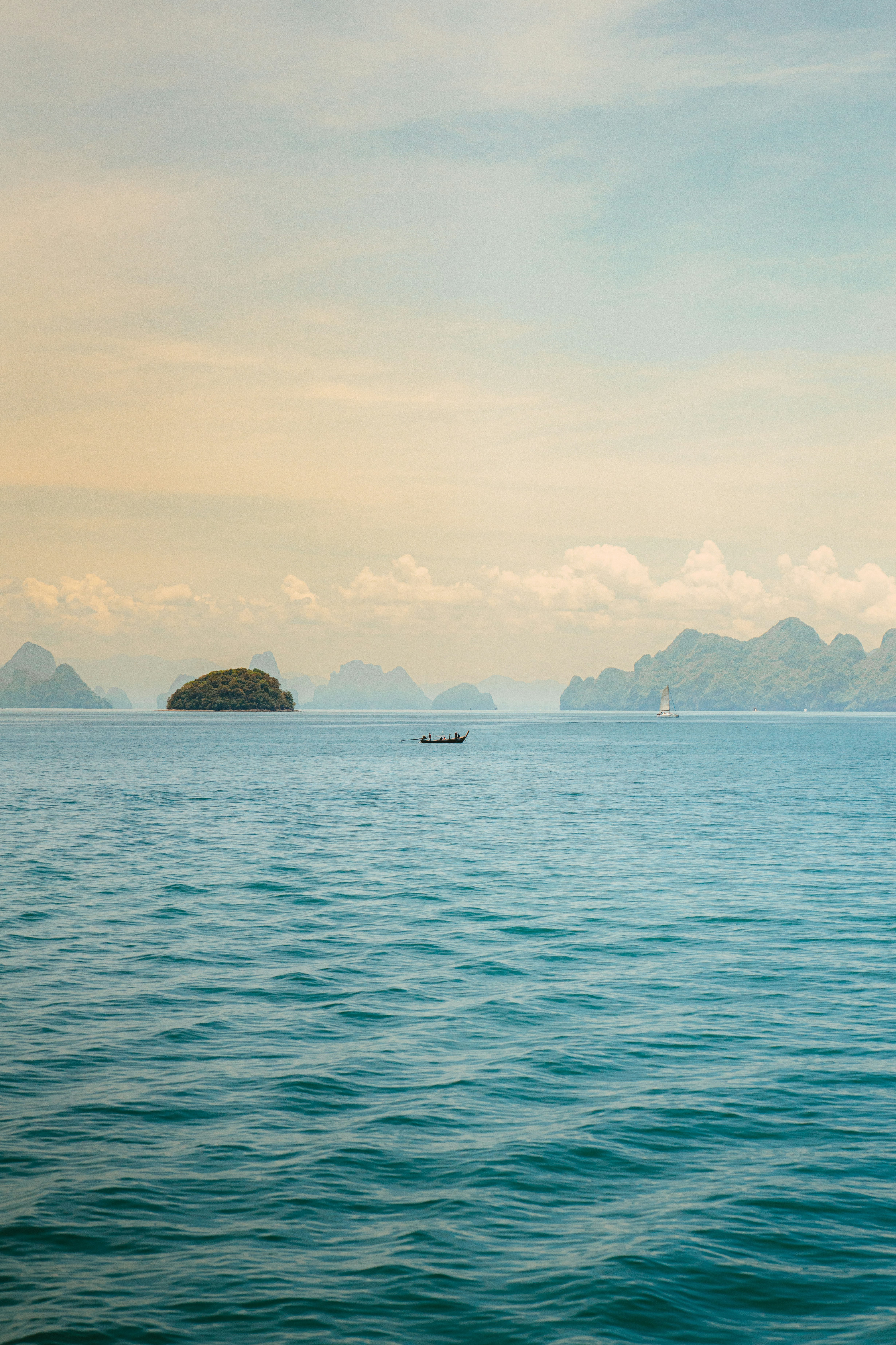 Boat sailing through a beautiful seascape with islands.