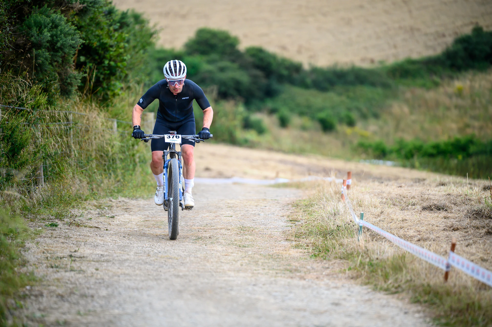 Cyclist rides a bike on a dirt path.