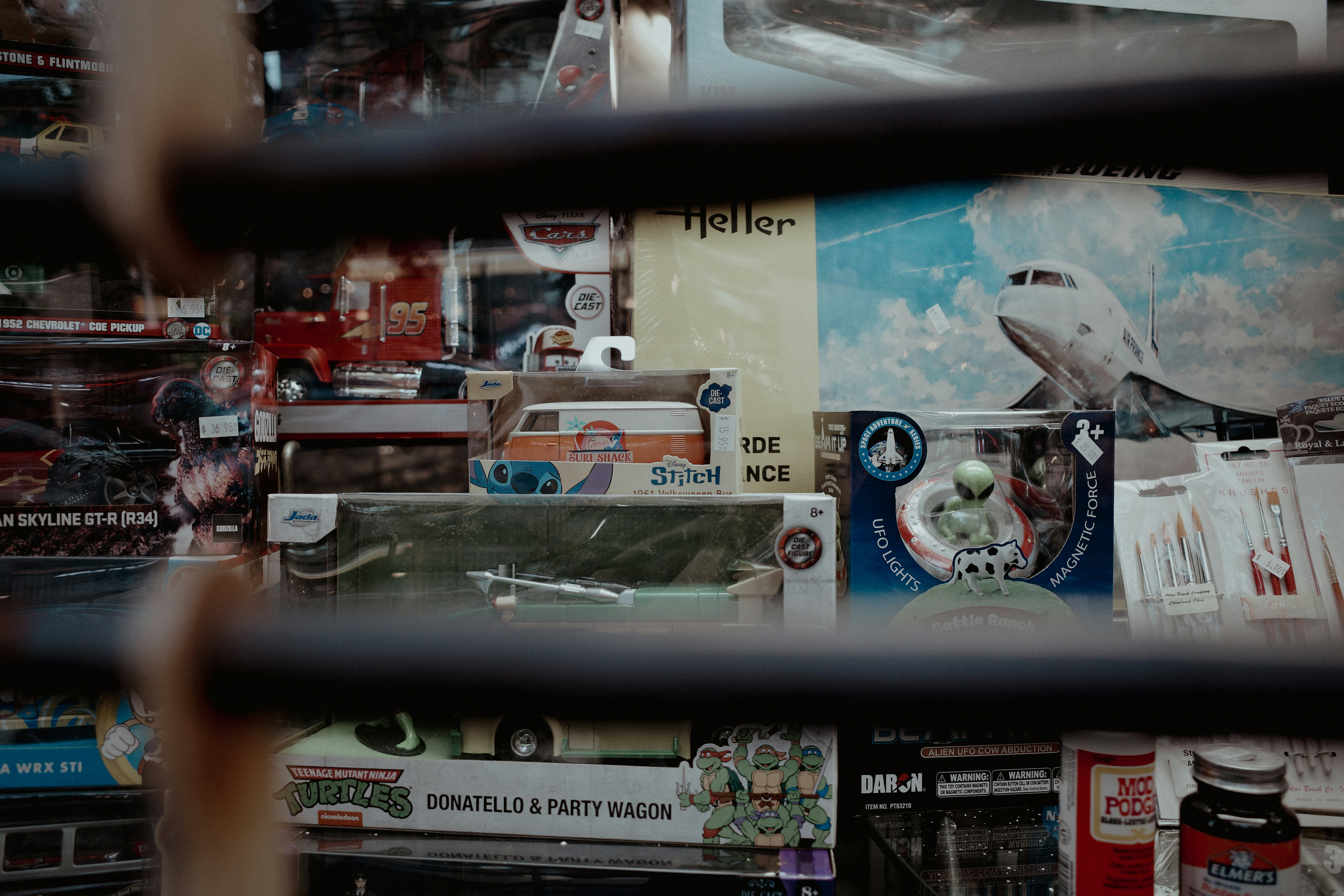 Toys and collectibles are displayed behind a fence.