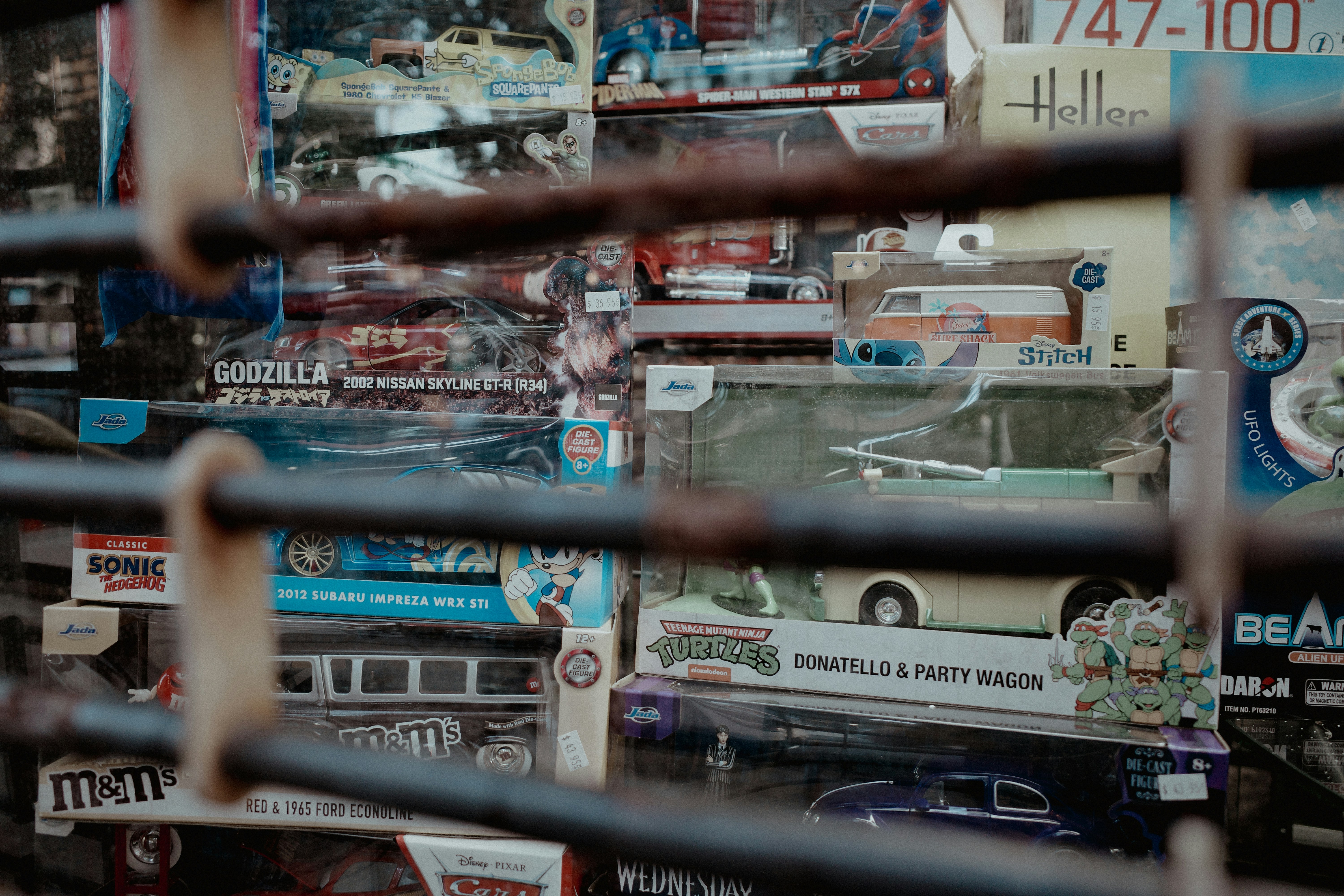 Toys and collectibles are behind a metal gate.