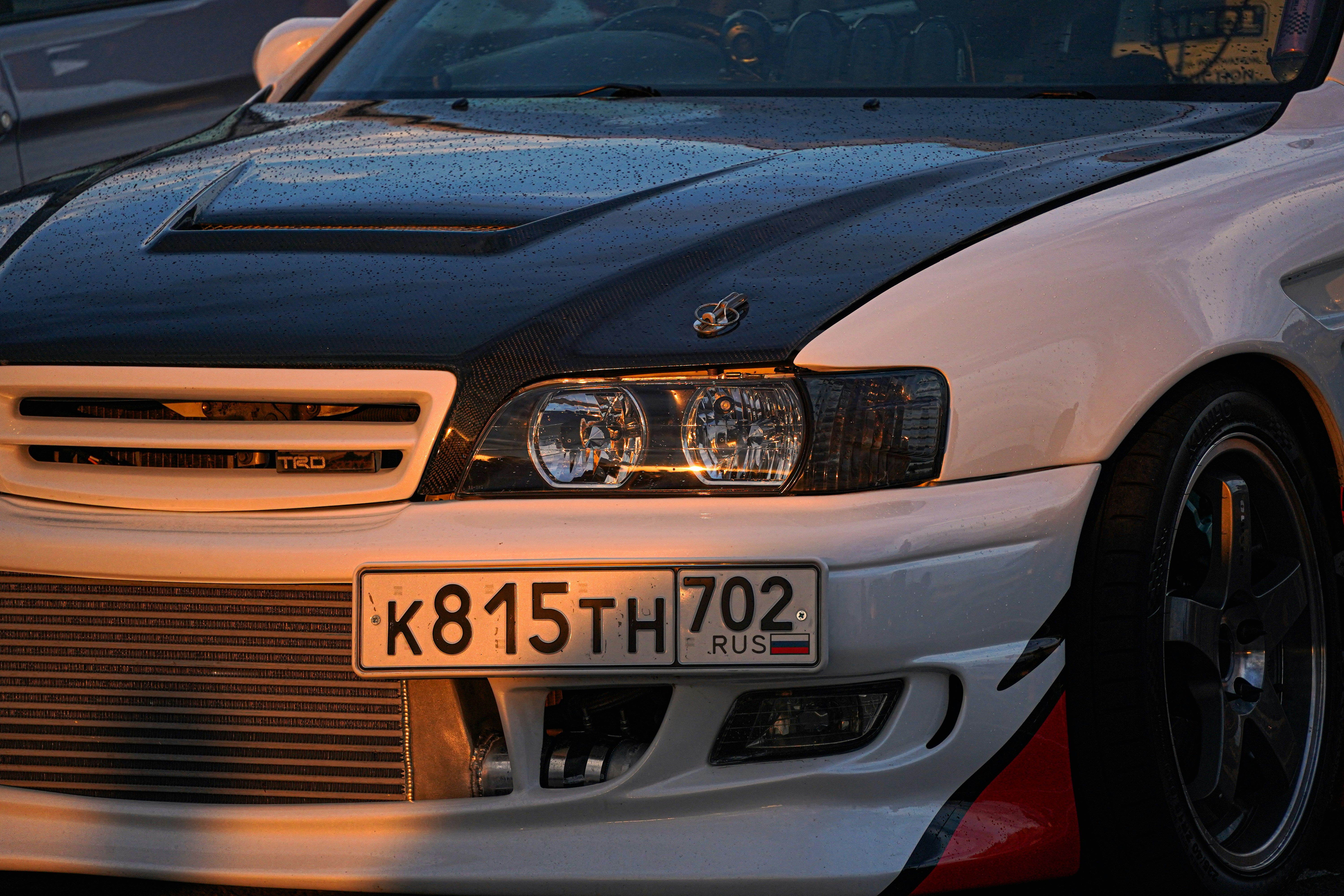 A white car with a black hood.