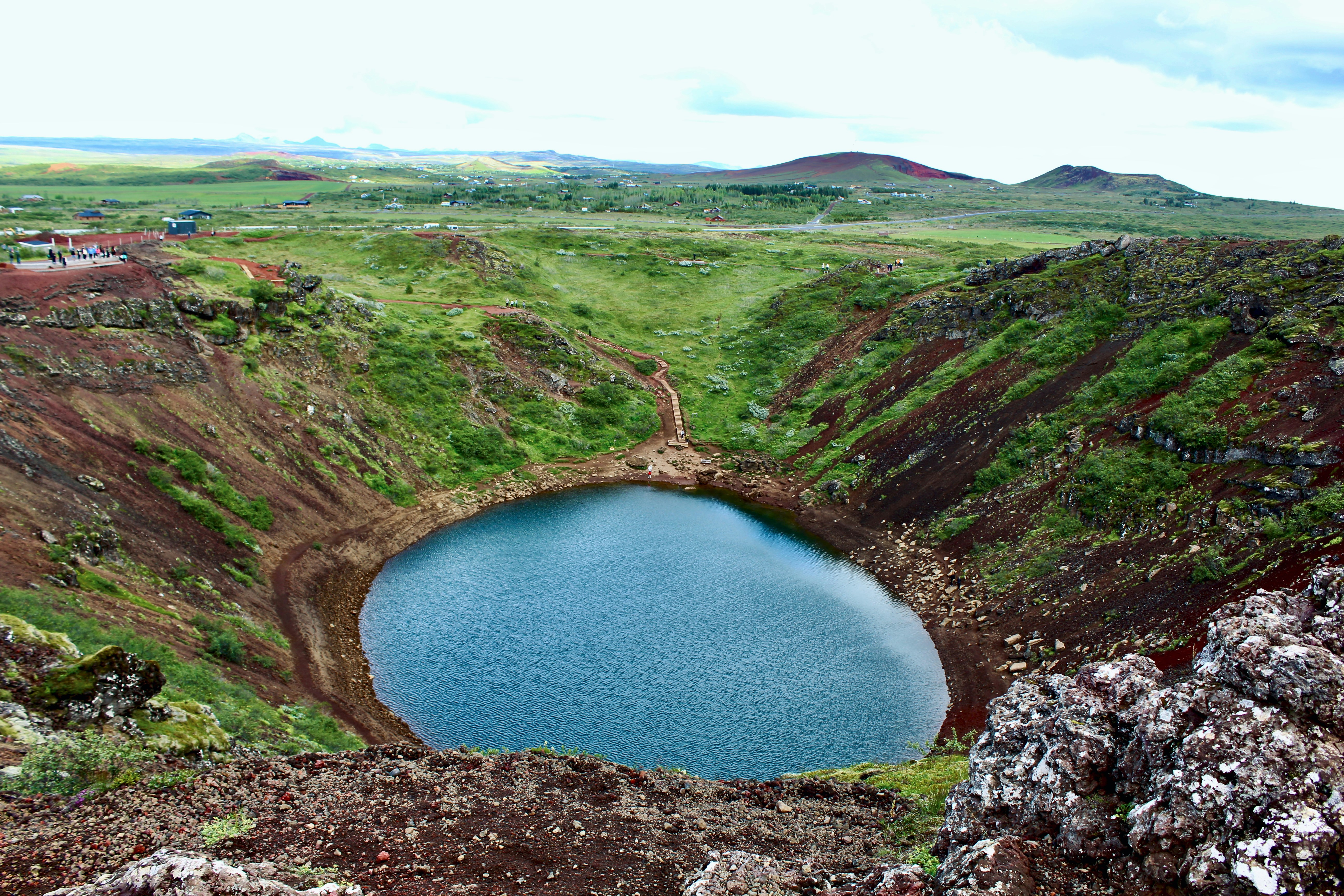 A crater lake surrounded by green hills.
