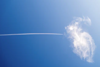 Airplane contrail interacts with a cloud.