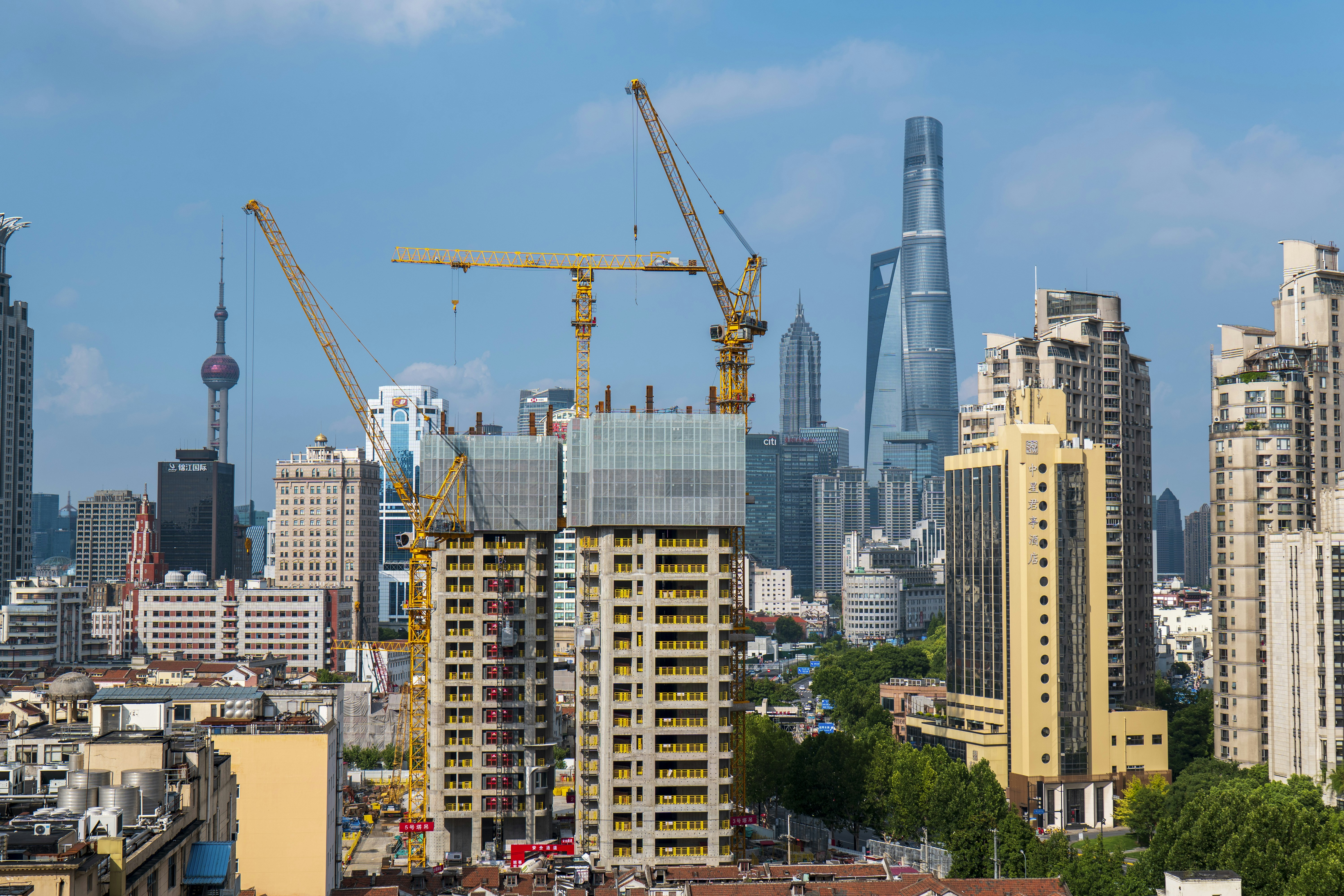 Skyscrapers and cranes dotting a bustling city skyline.