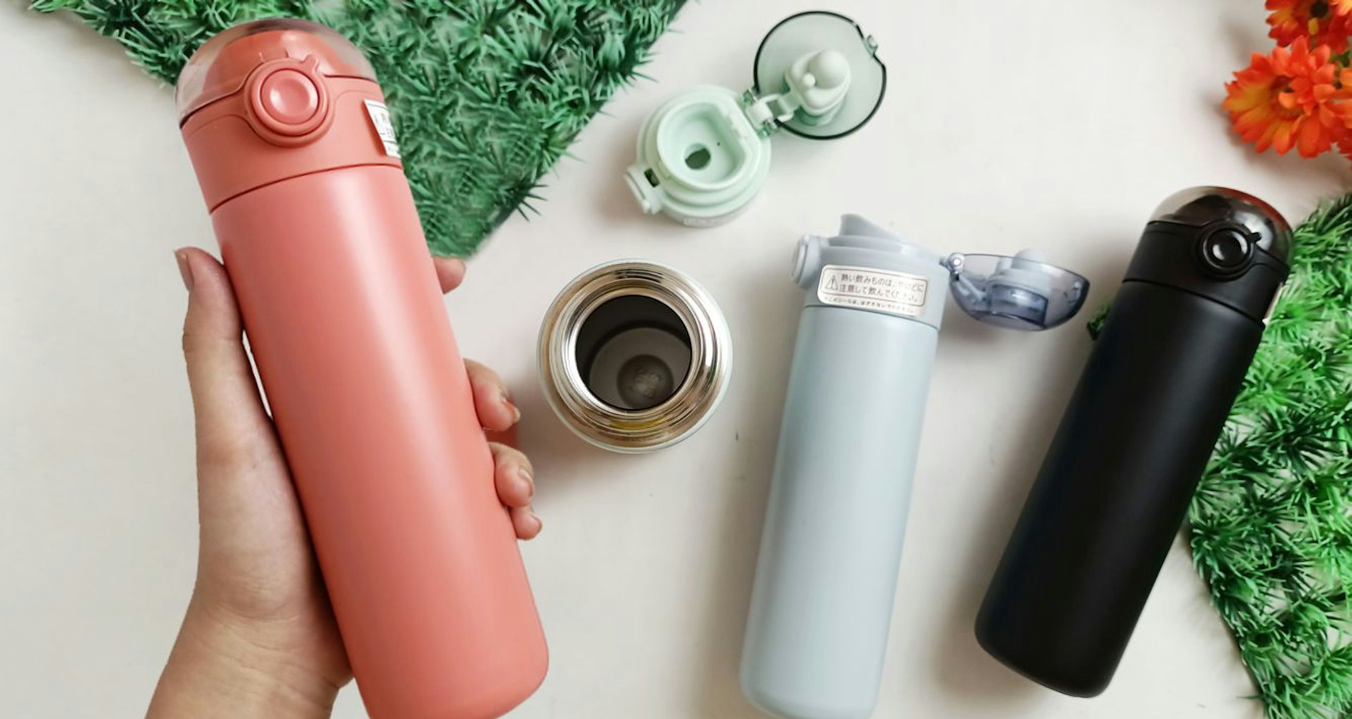 Several insulated bottles are neatly arranged on a table.