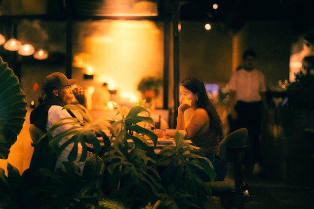 People are dining in a restaurant with dim lighting.