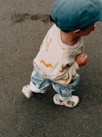 A small child is happily walking along the pavement.
