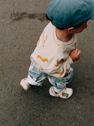 A small child is happily walking along the pavement.
