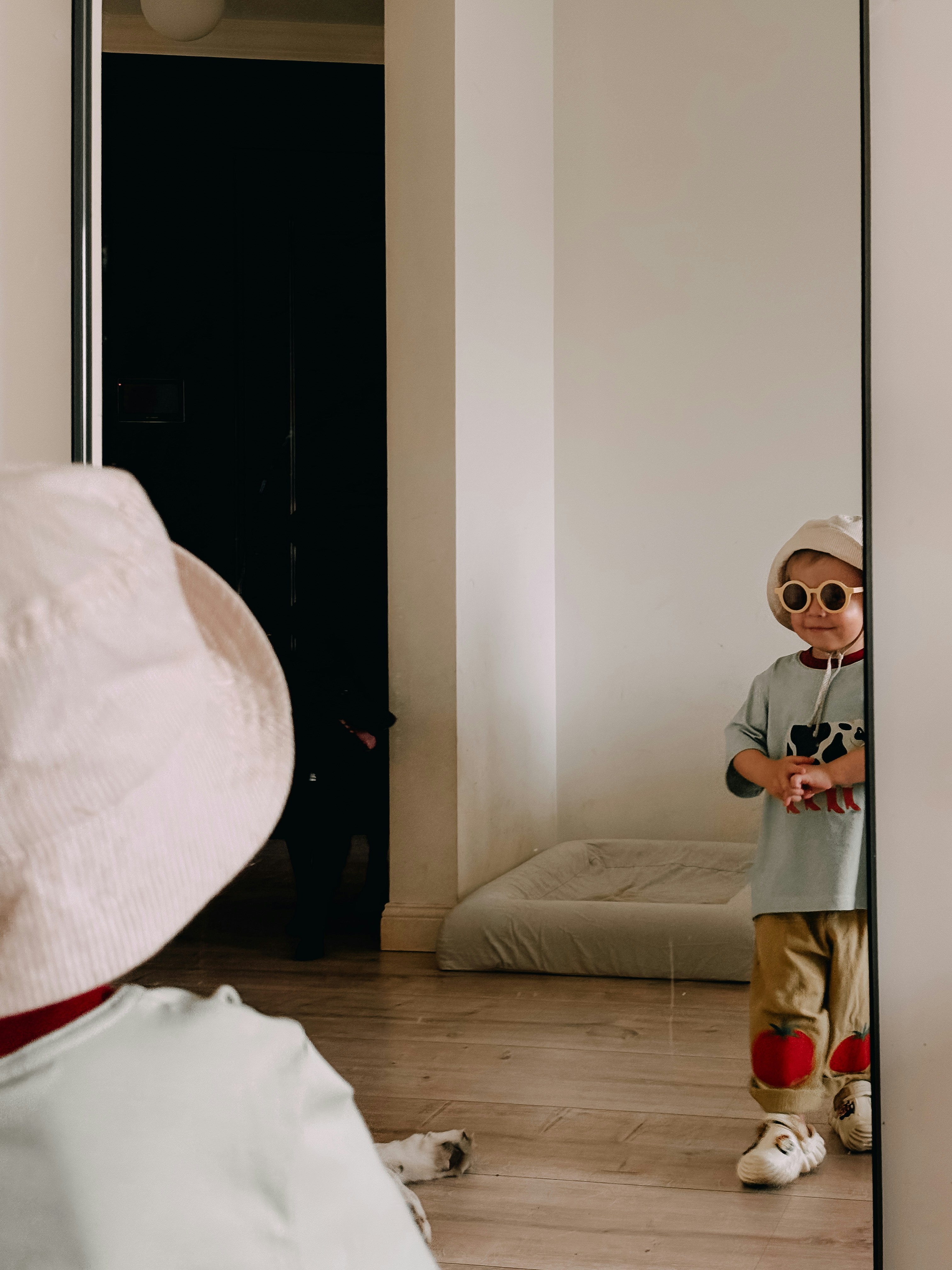 Child peers into a mirror, looking at their reflection.