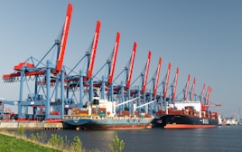 Cargo ships dock at a bustling harbor.