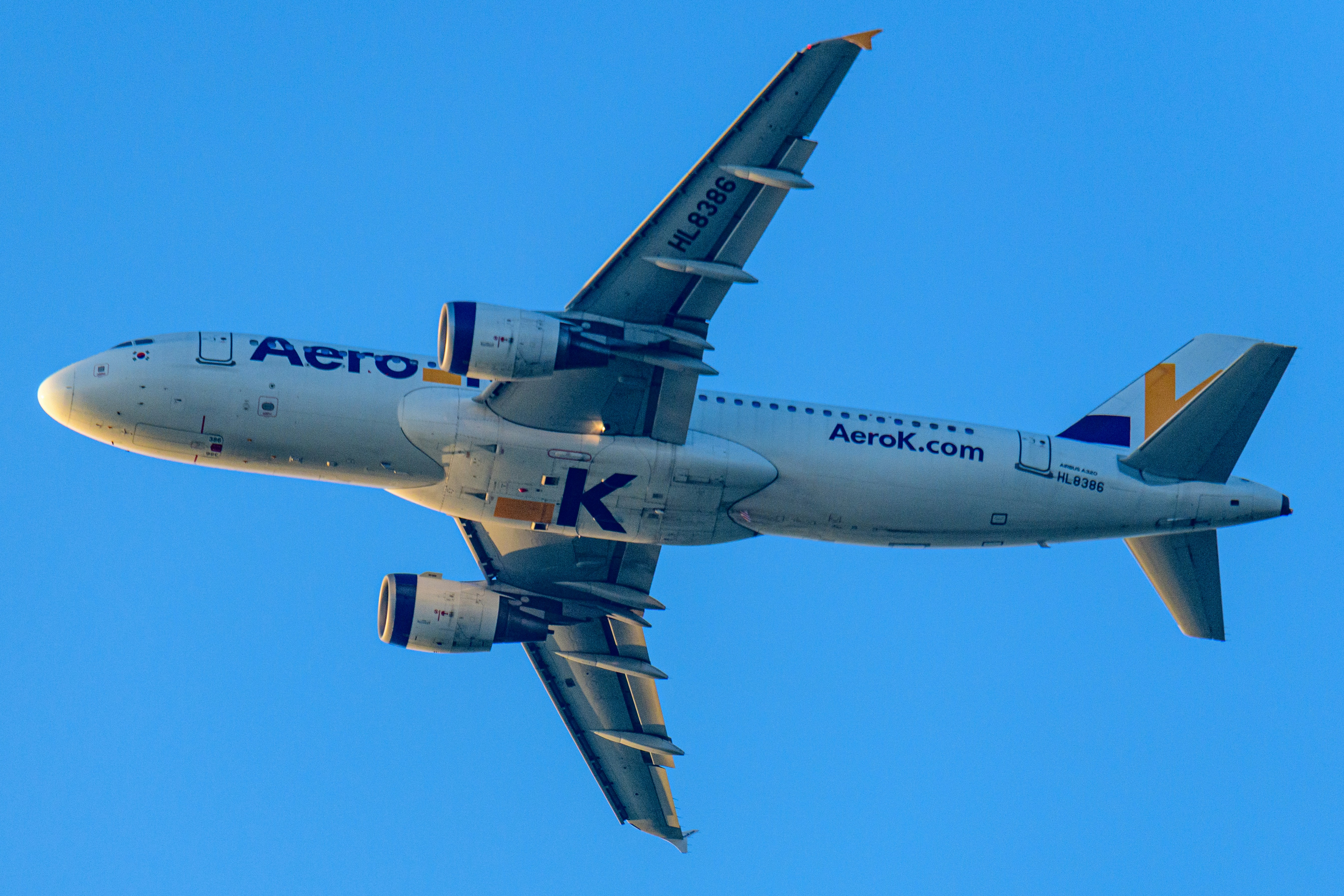 An airplane ascends against a clear blue sky.