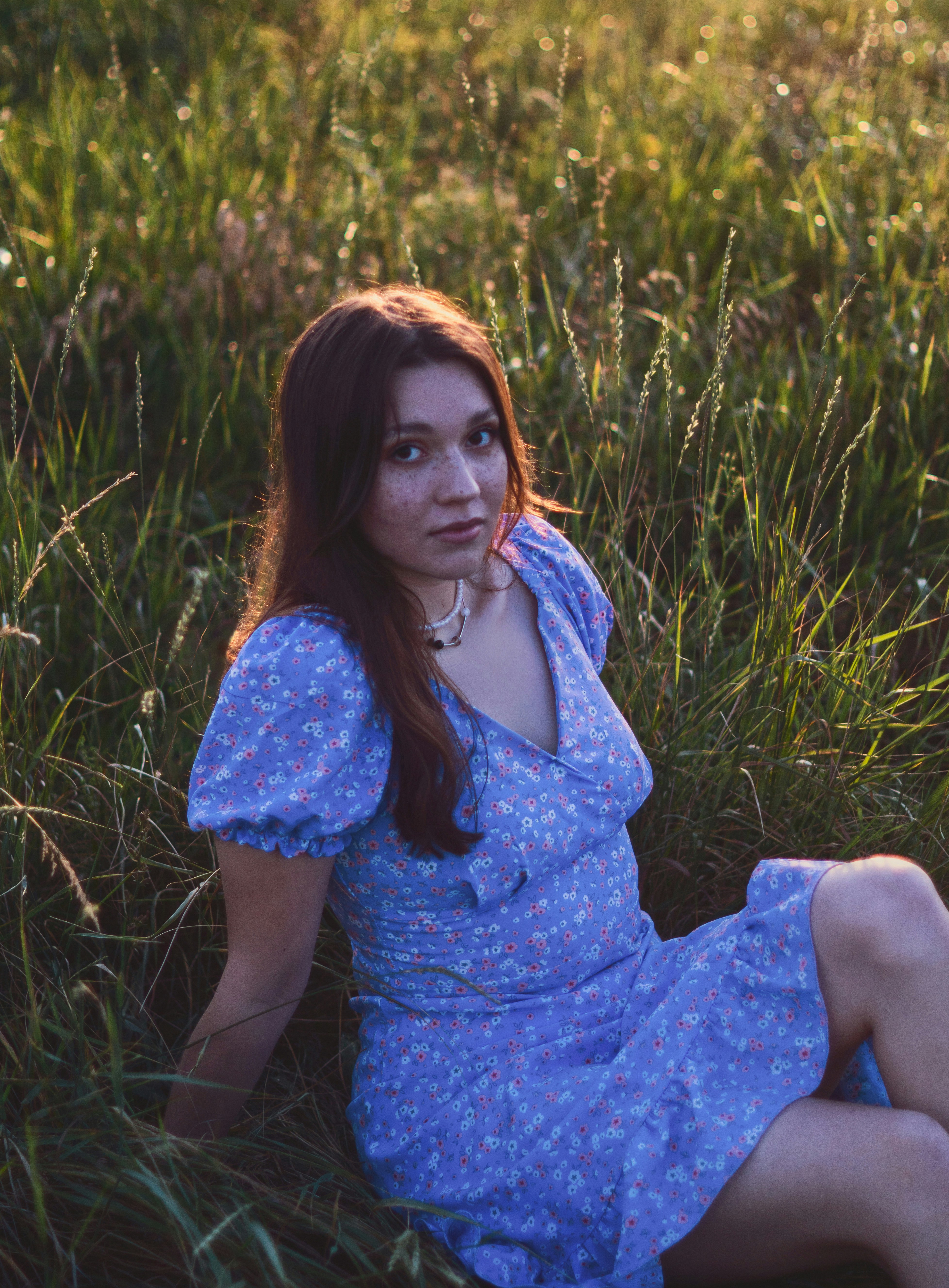Young woman rests in a field of grass.