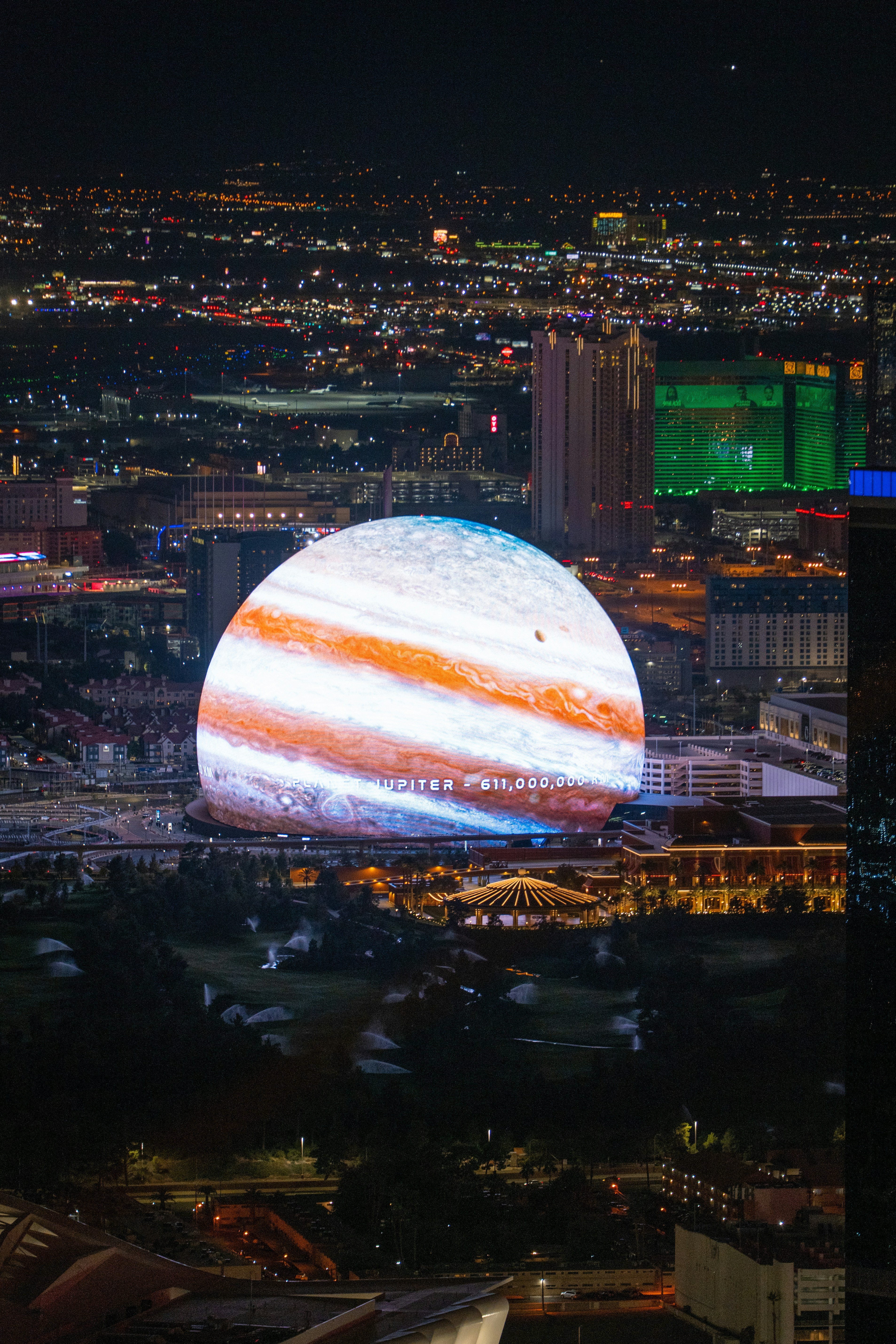 Jupiter projects over a cityscape at night.