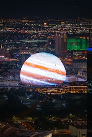 Jupiter projects over a cityscape at night.