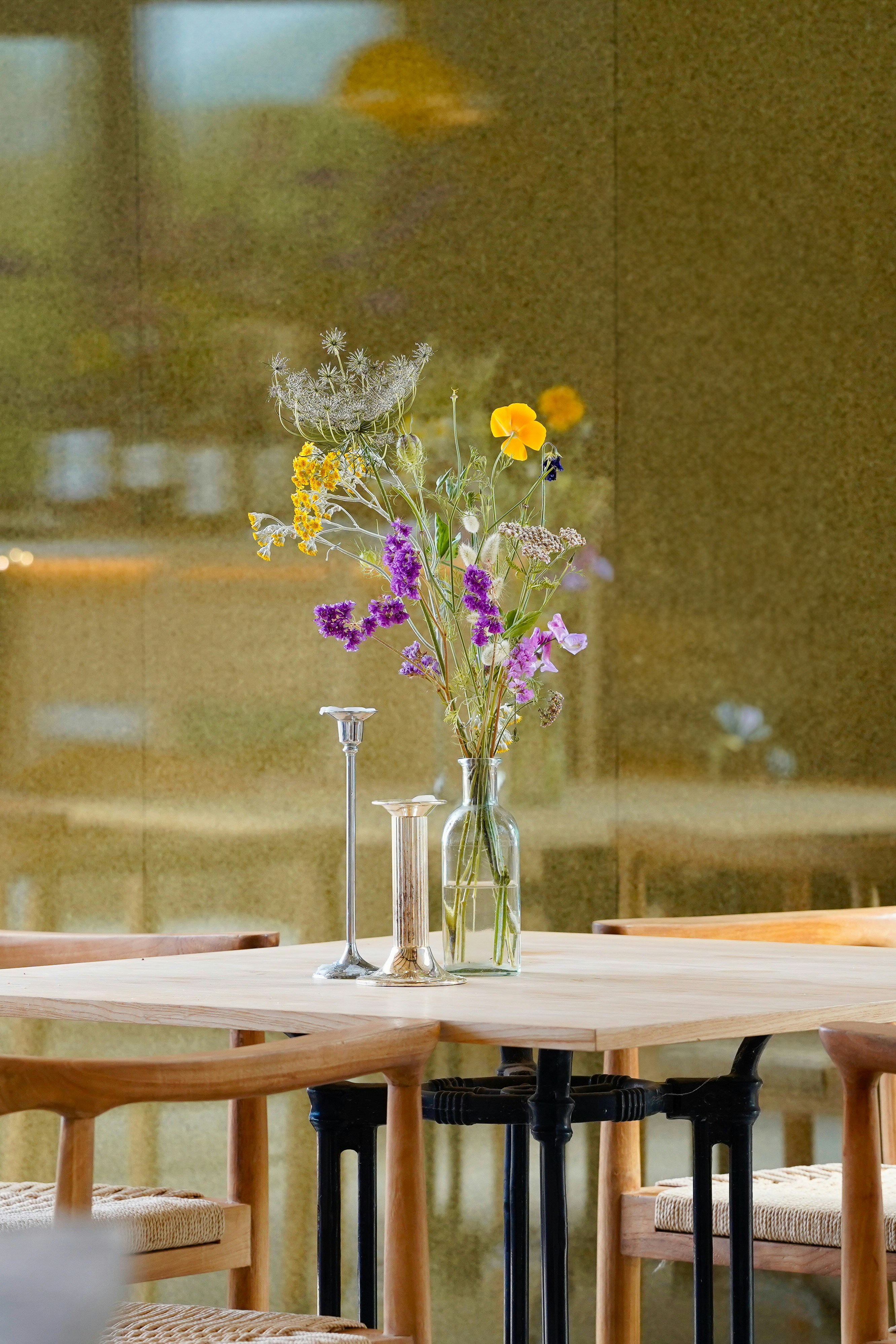 Flowers and candleholders grace a table setting.