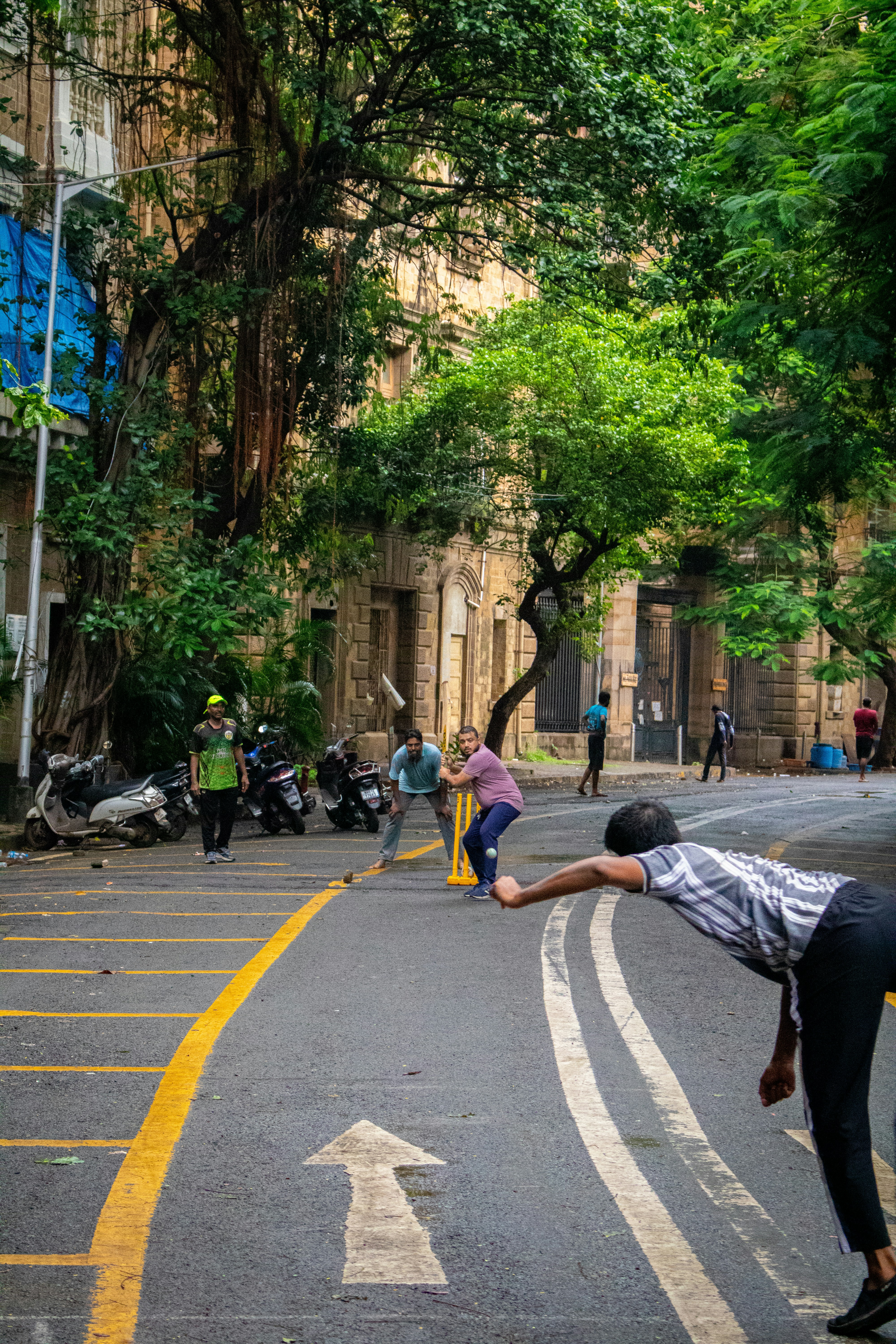 People play cricket on a street in india.