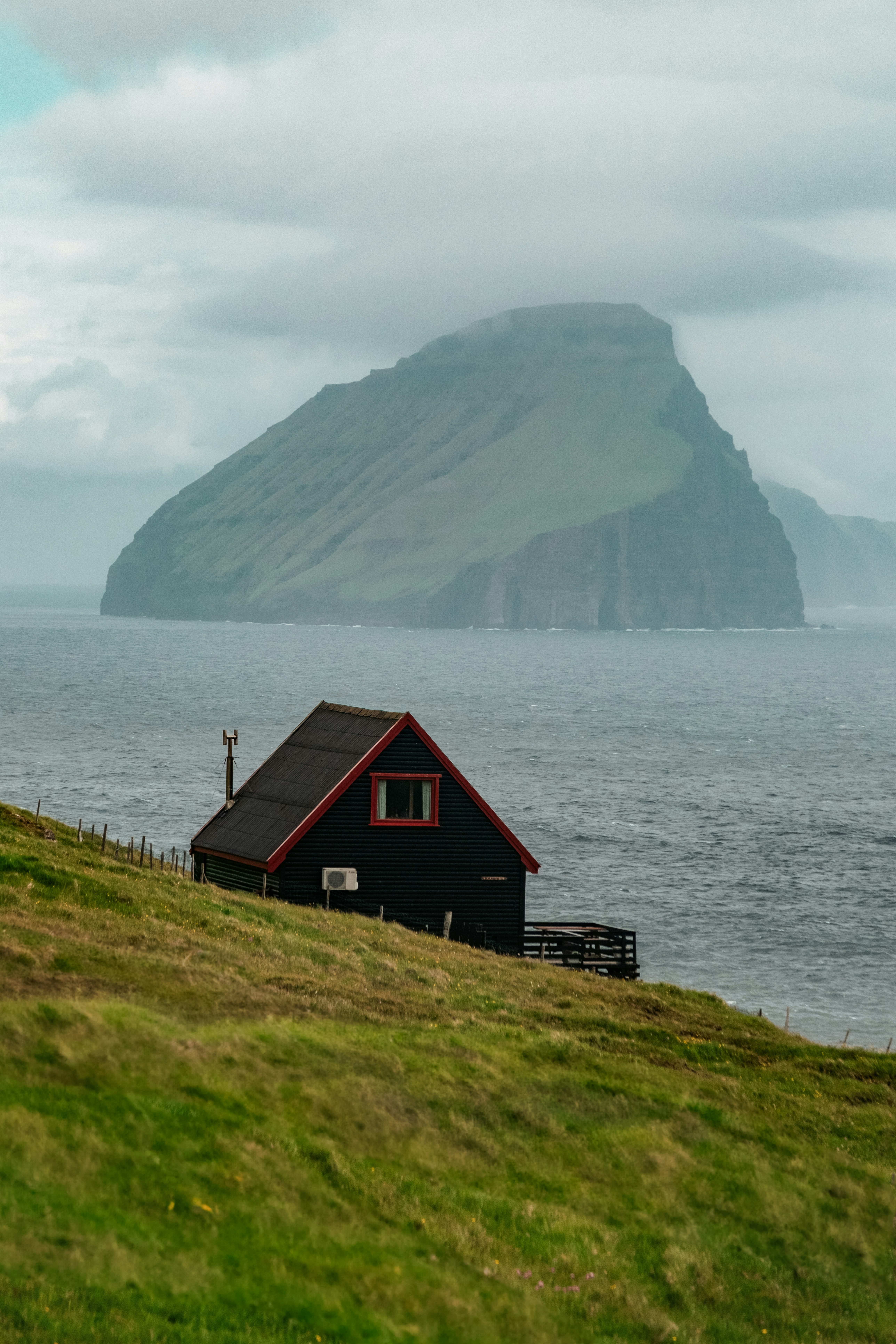 House sits on a hill with a stunning mountain view.