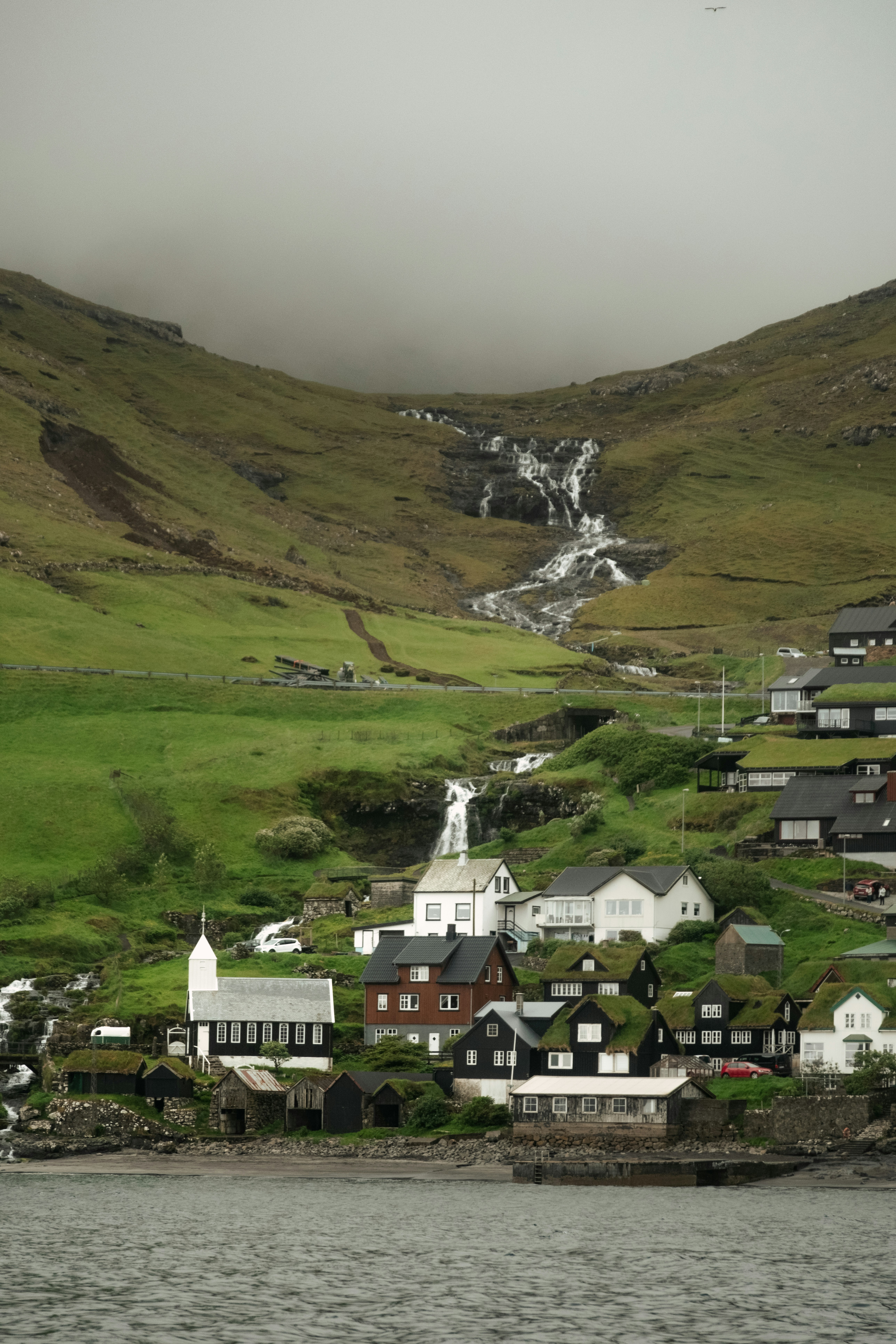 A lush green village nestled near a waterfall.
