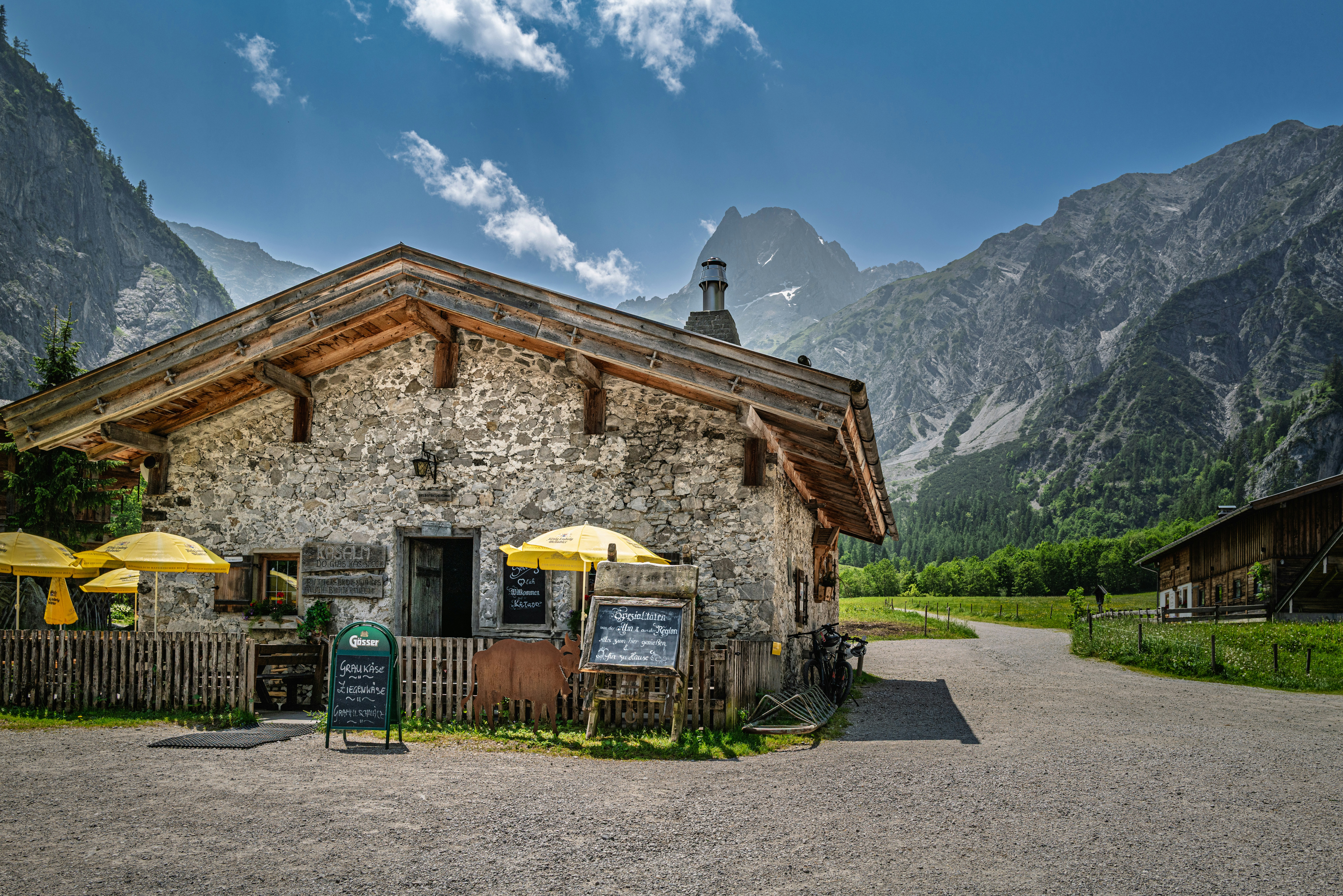 A stone house is surrounded by mountains.