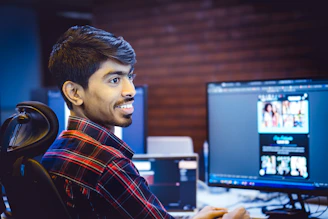 A man smiles while working at his computer.
