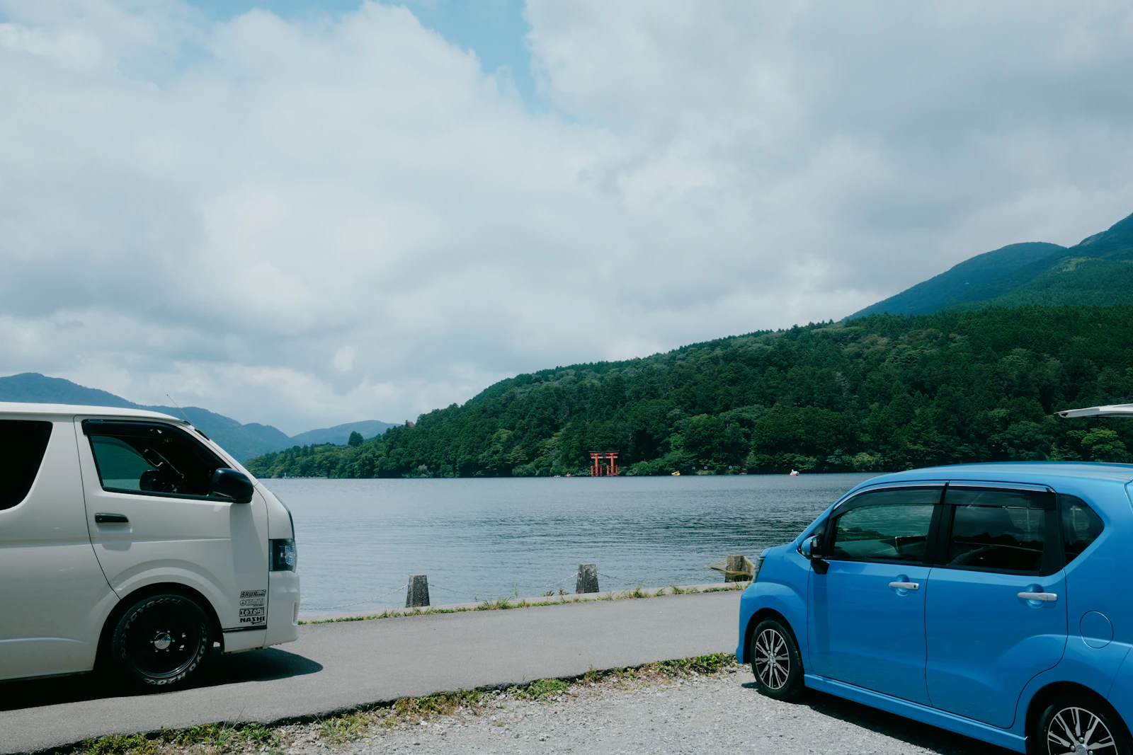 湖のほとりに停まる車と山の景色