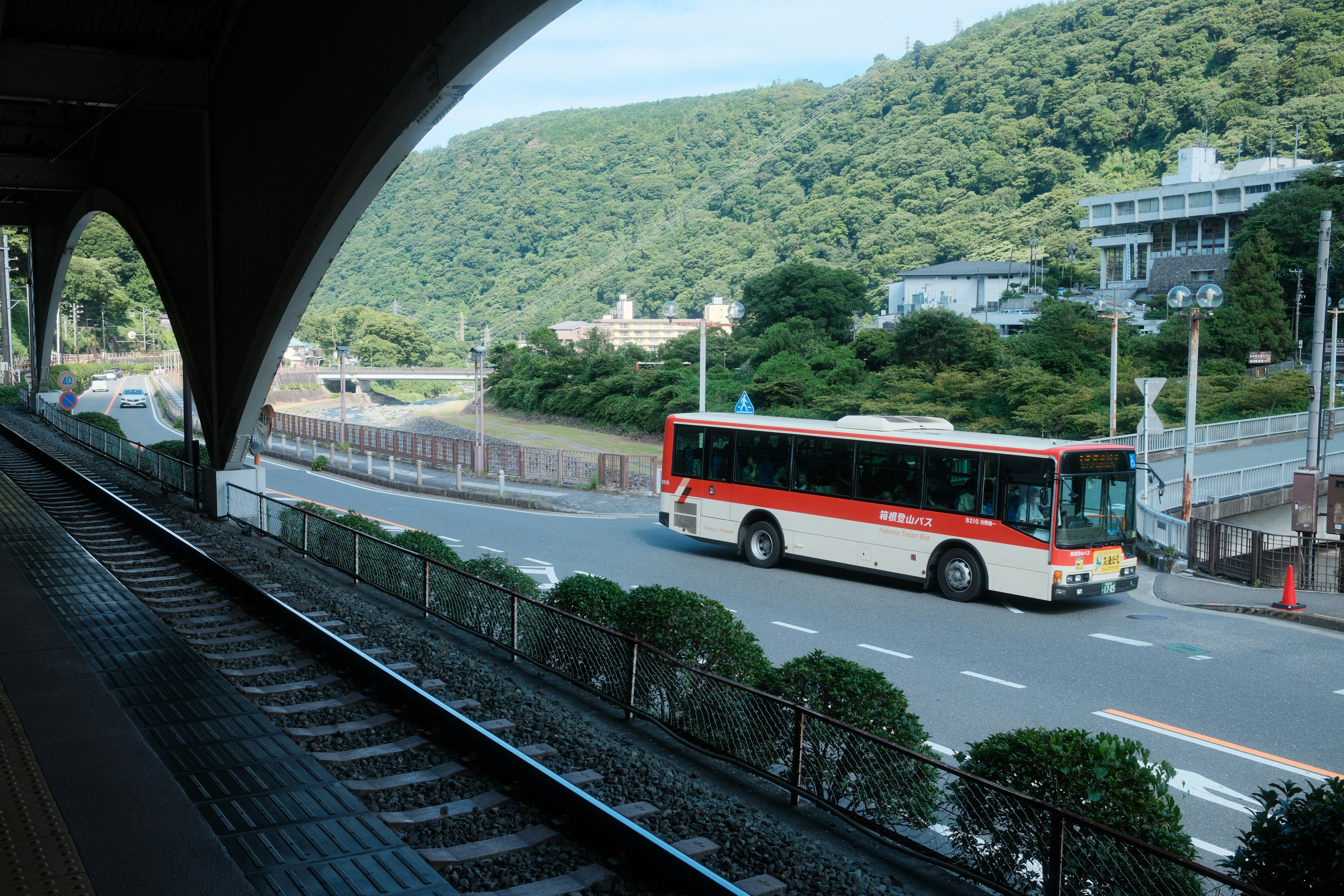 A bus drives past rails and a mountain. photo – Free Car Image on Unsplash