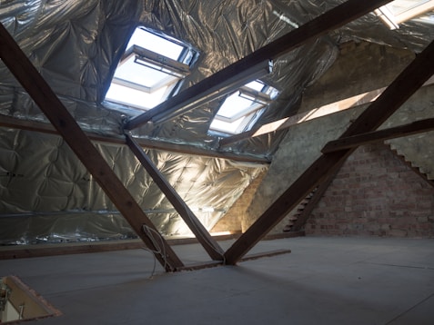 An attic with insulation and skylights is shown.