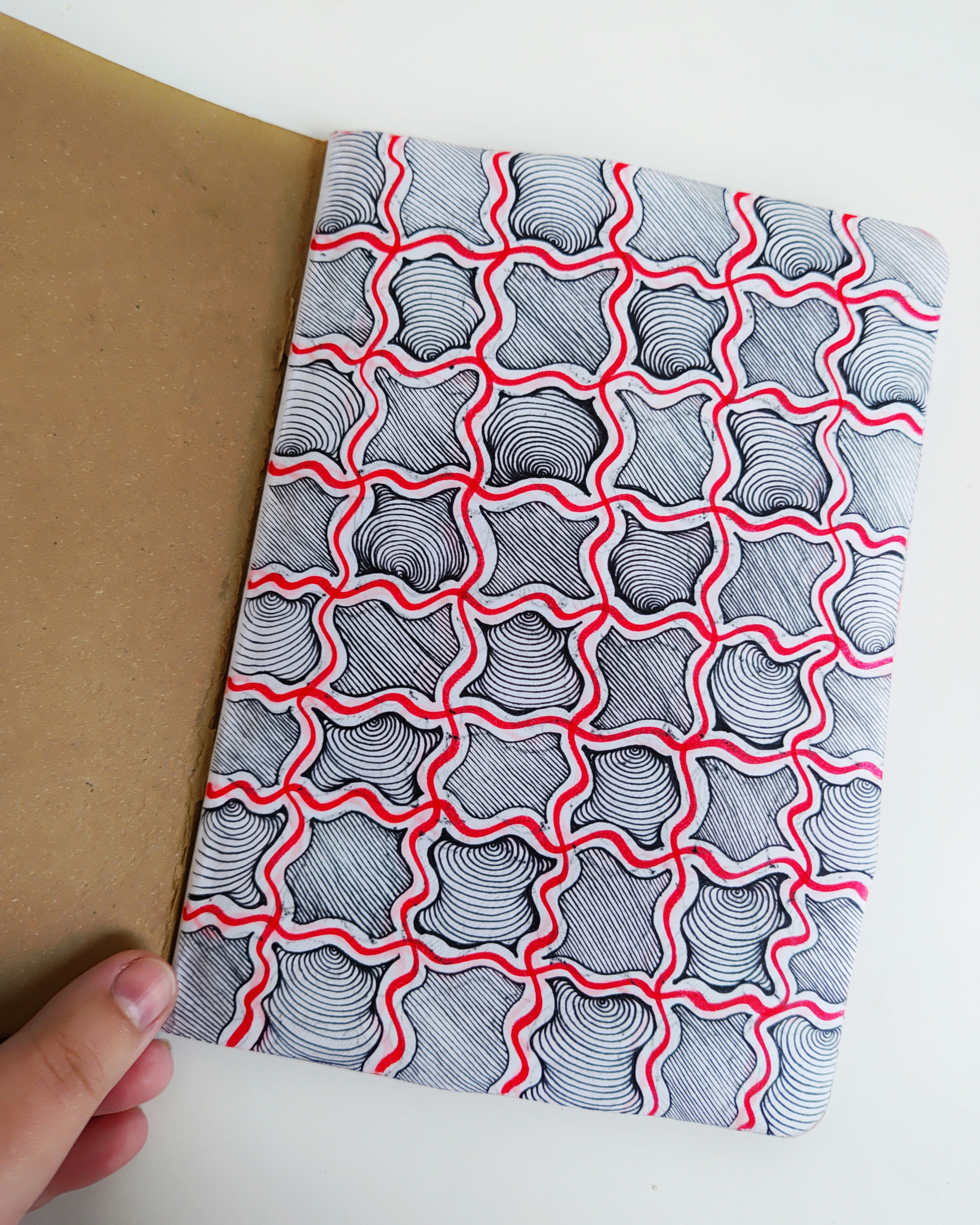 Hand-drawn pattern in red and black lines.