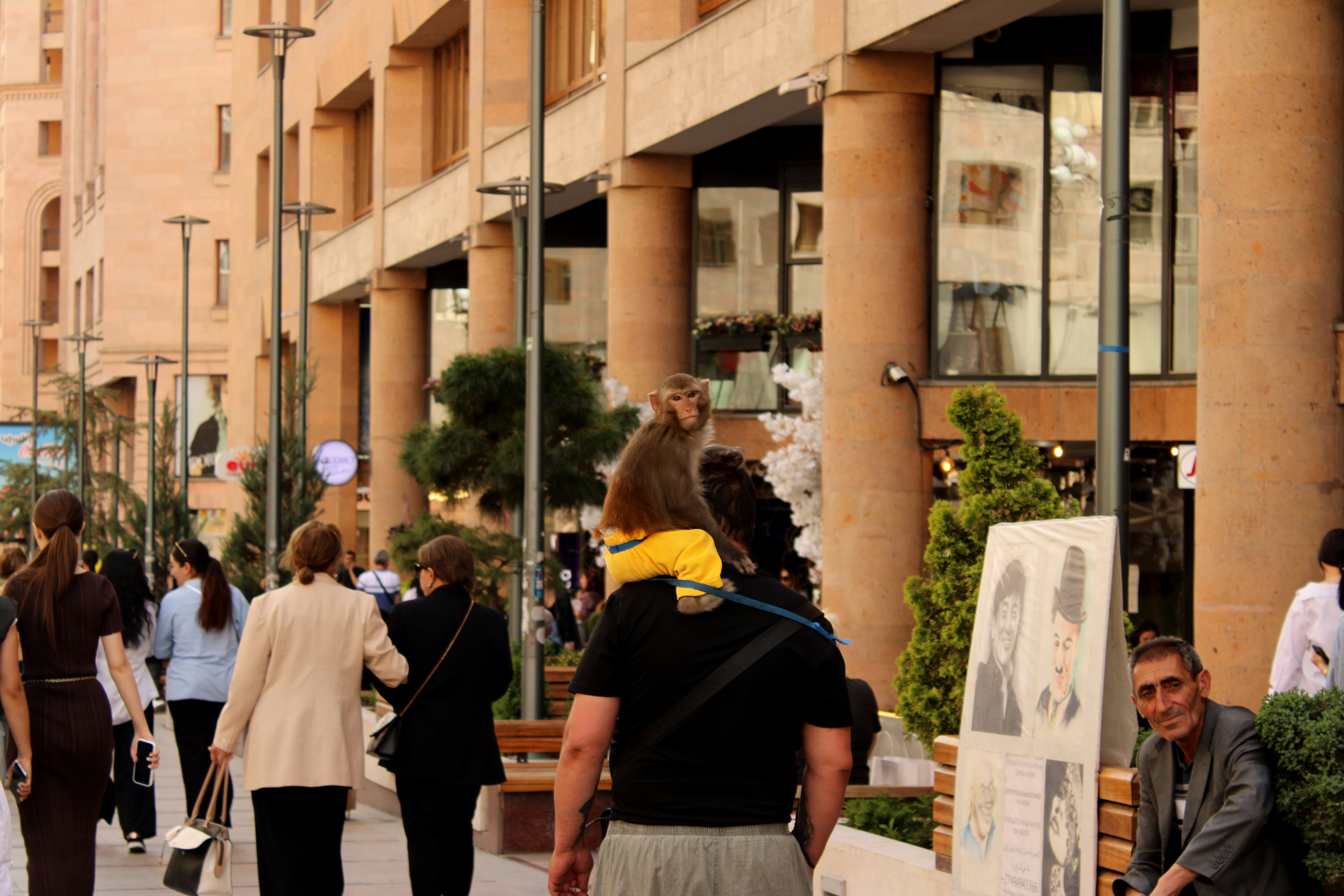 People walk along a city street with buildings.