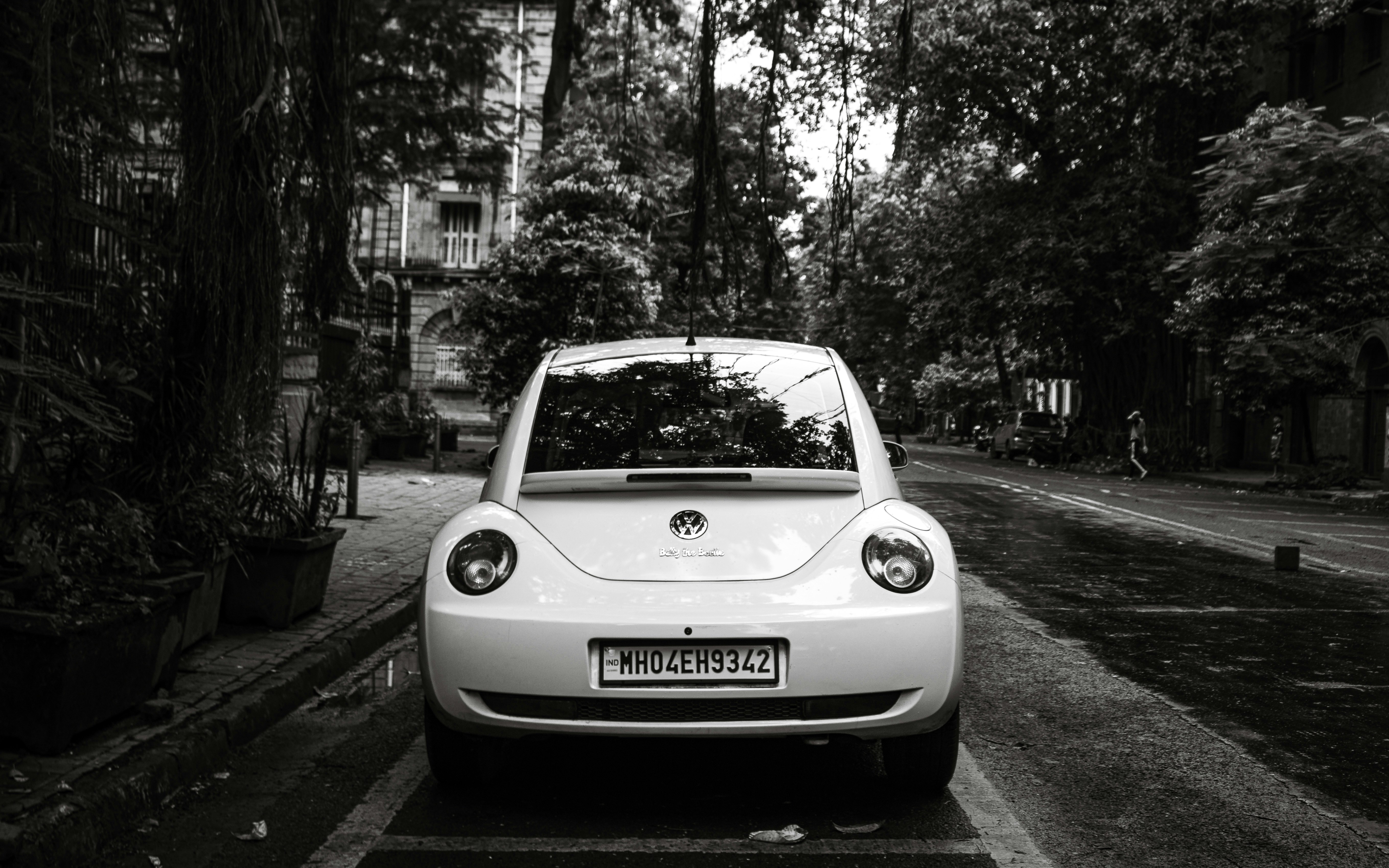 Compact electric car plugged into a curbside charger in a busy city street