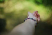 A hand with a bracelet reaches out.