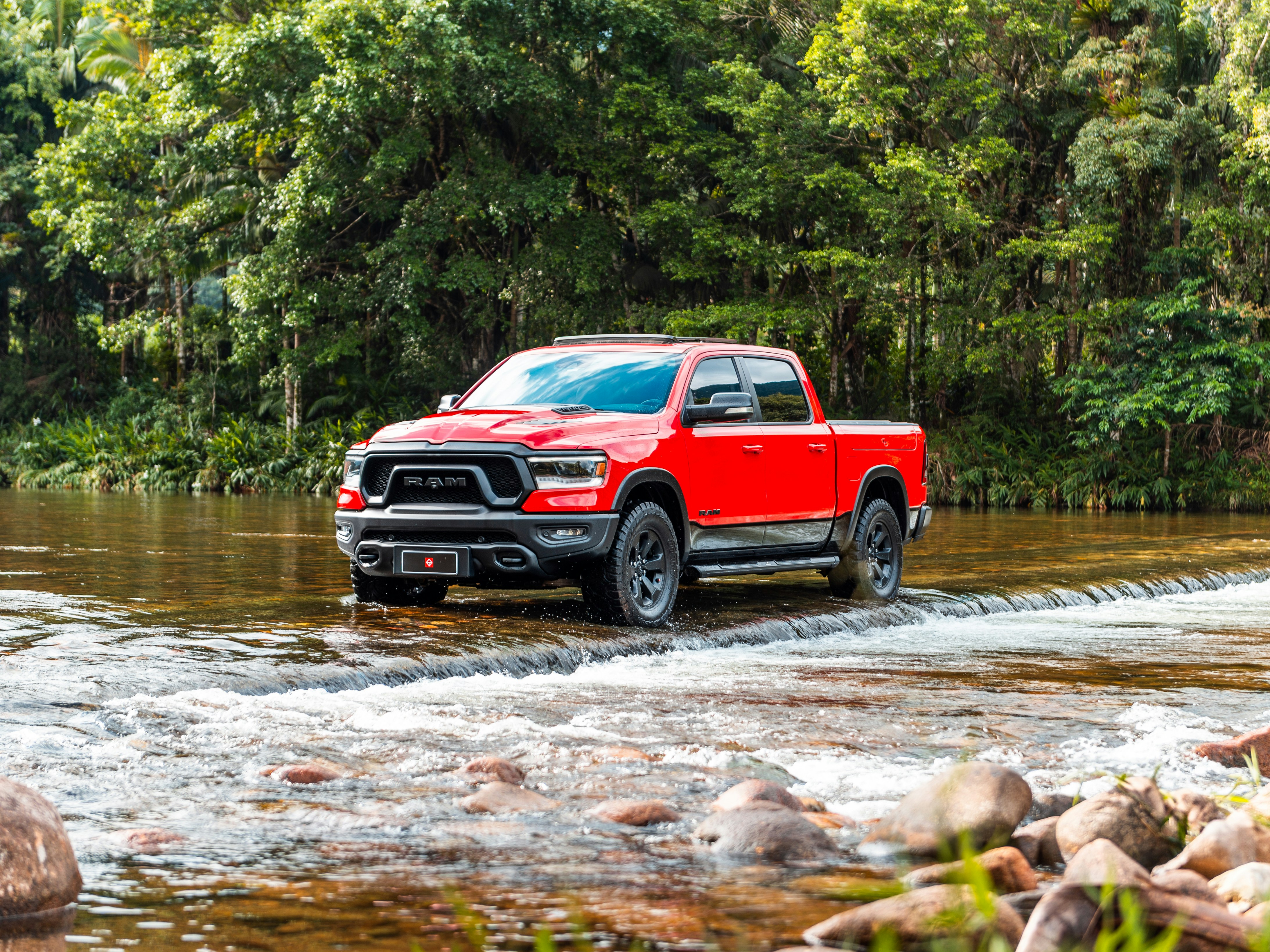 A red truck wades through the water