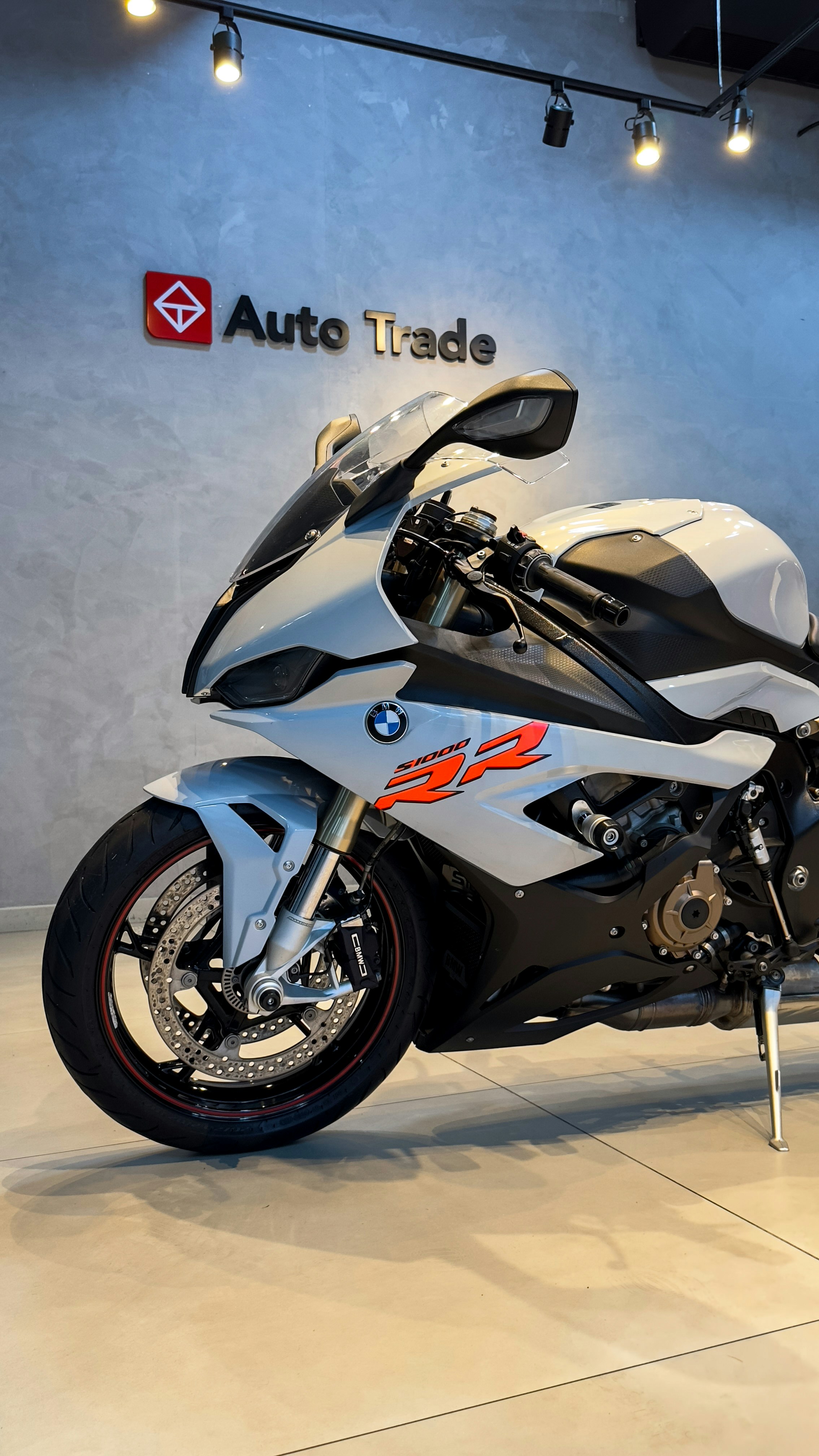 A white BMW motorcycle displayed in a showroom.