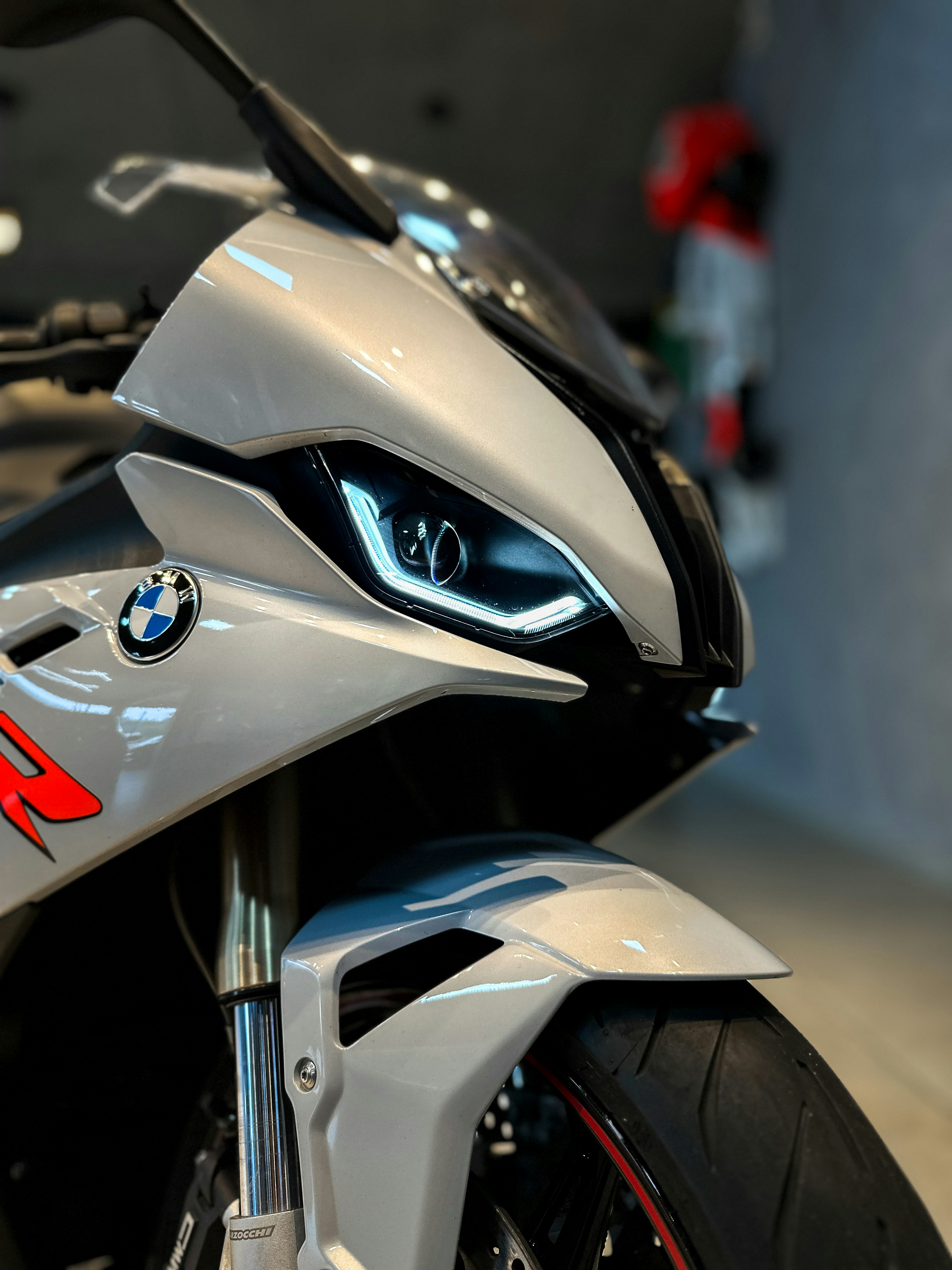 A silver BMW motorcycle stands in focus.