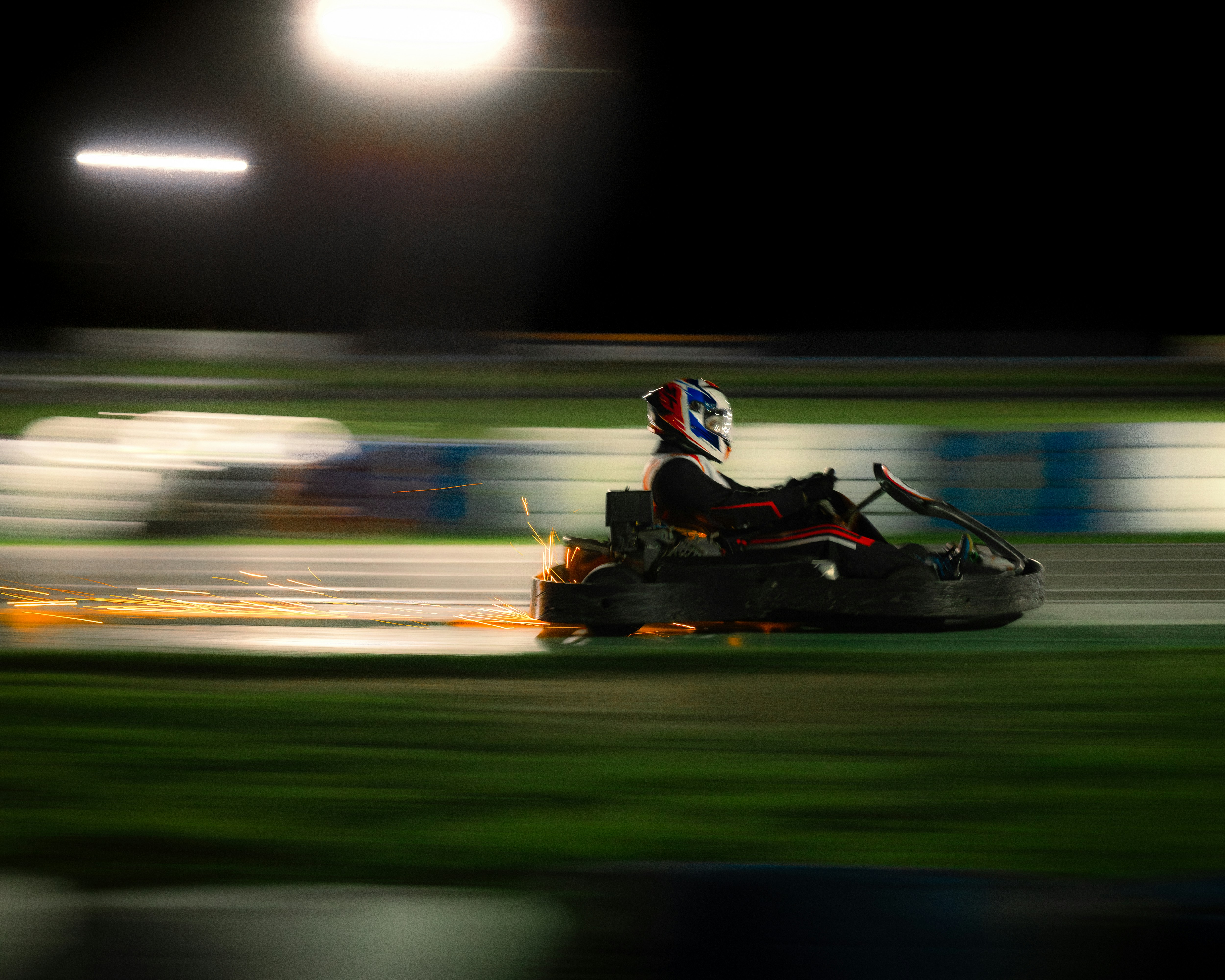 Go-kart racer speeding down the track at night