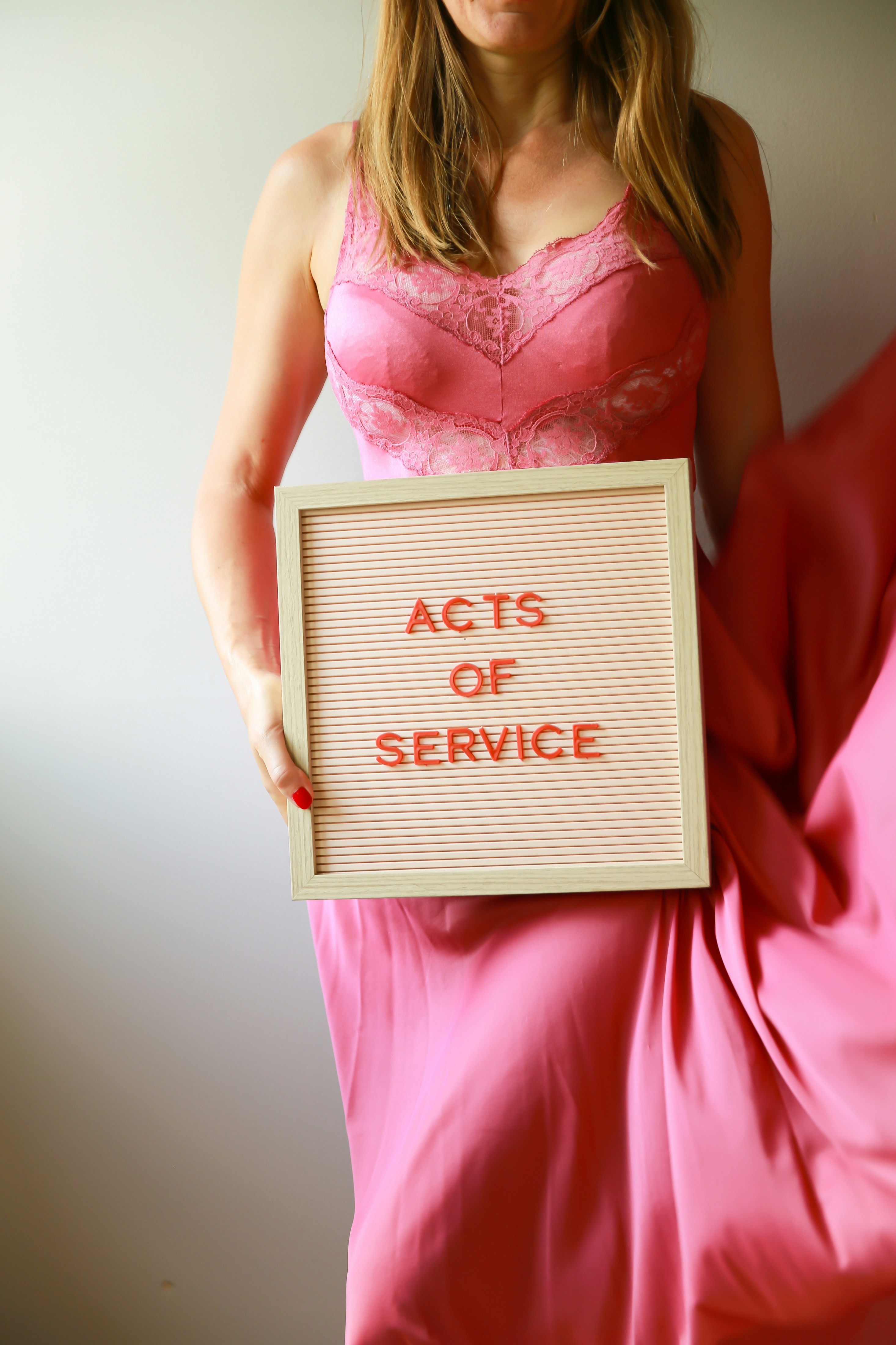 Die Frau hält ein Schild mit der Aufschrift "Taten des Dienstes".