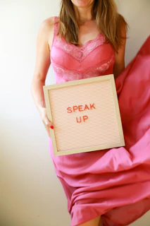 Woman holds sign that says "speak up."