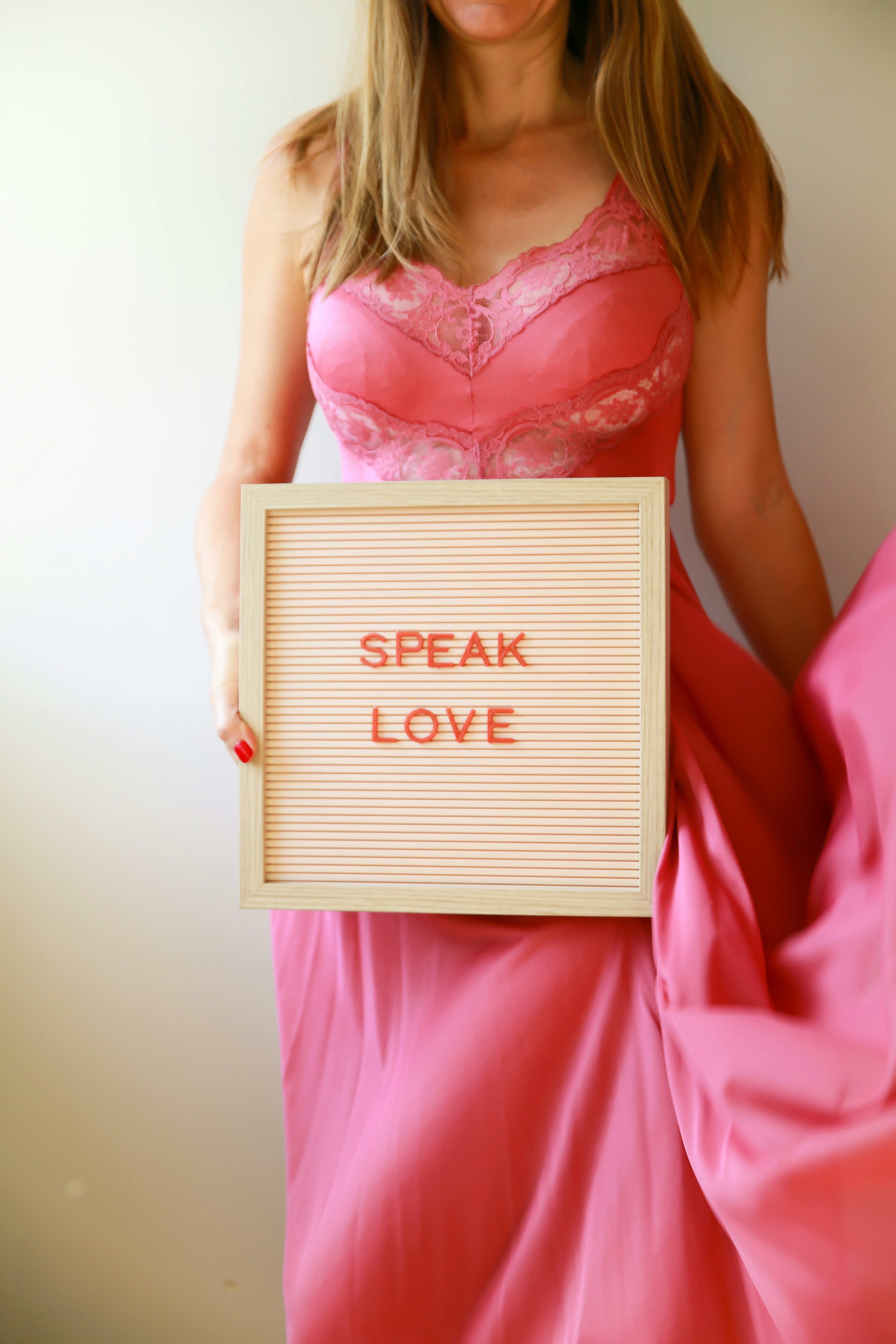 Woman holds sign that reads, "speak love."