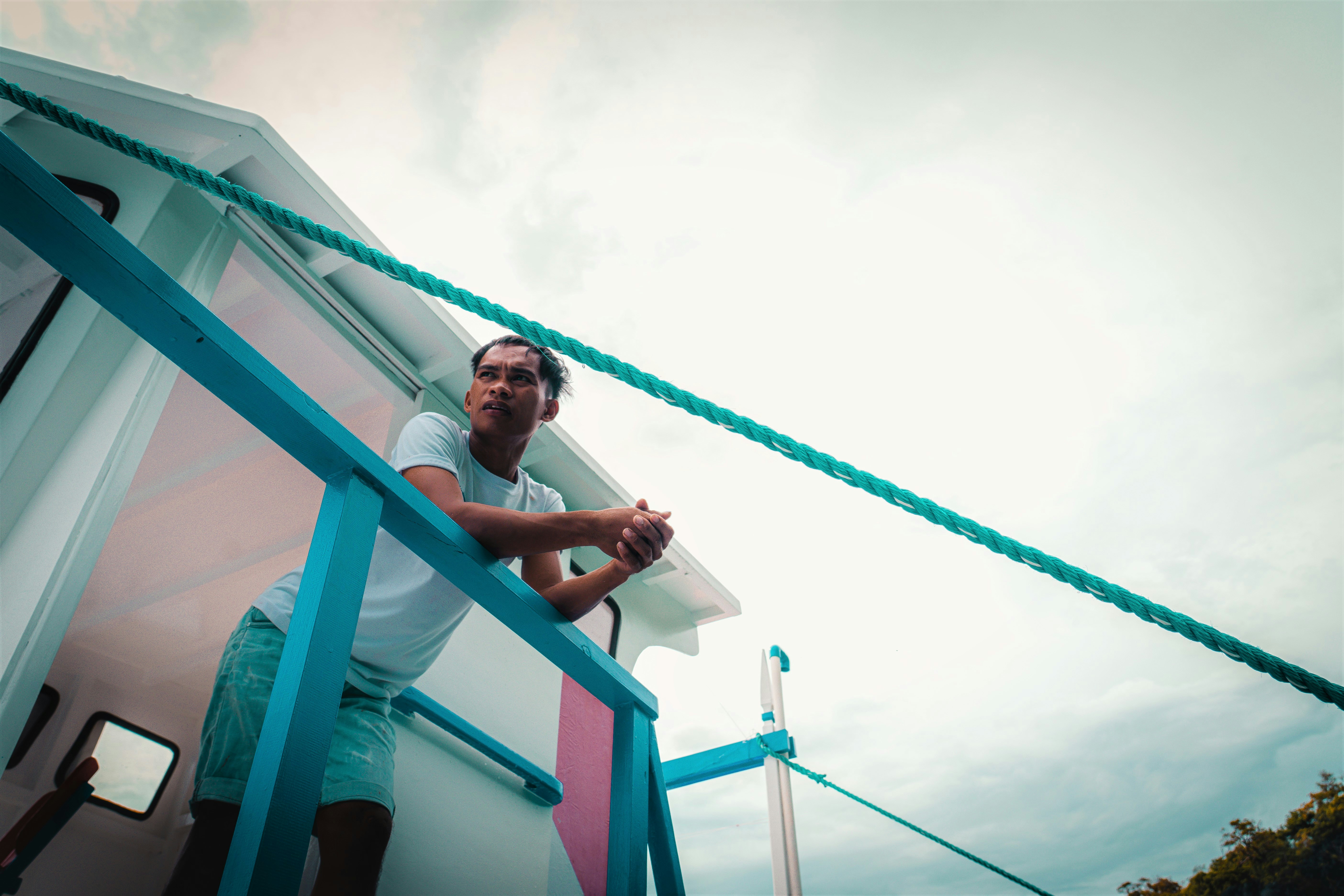 Man leans on the railing, looking out at something.