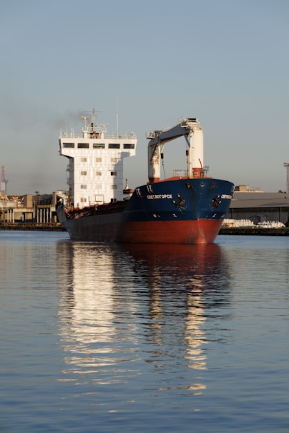 A cargo ship sails on calm water.