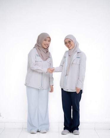 Two women are shaking hands and smiling.