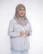 A smiling woman in a hijab and jacket is posing.