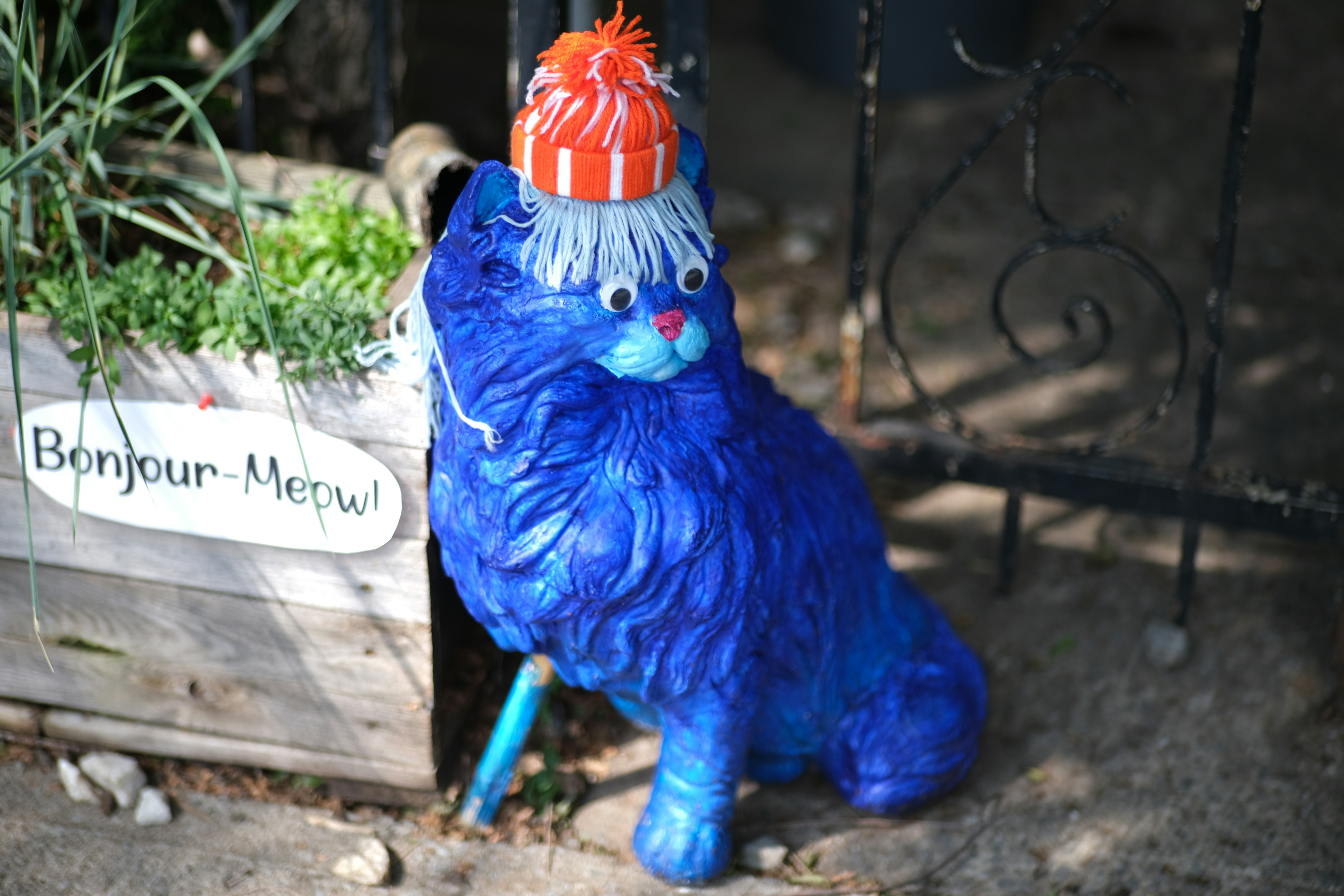 A blue cat sculpture adorns the yard.
