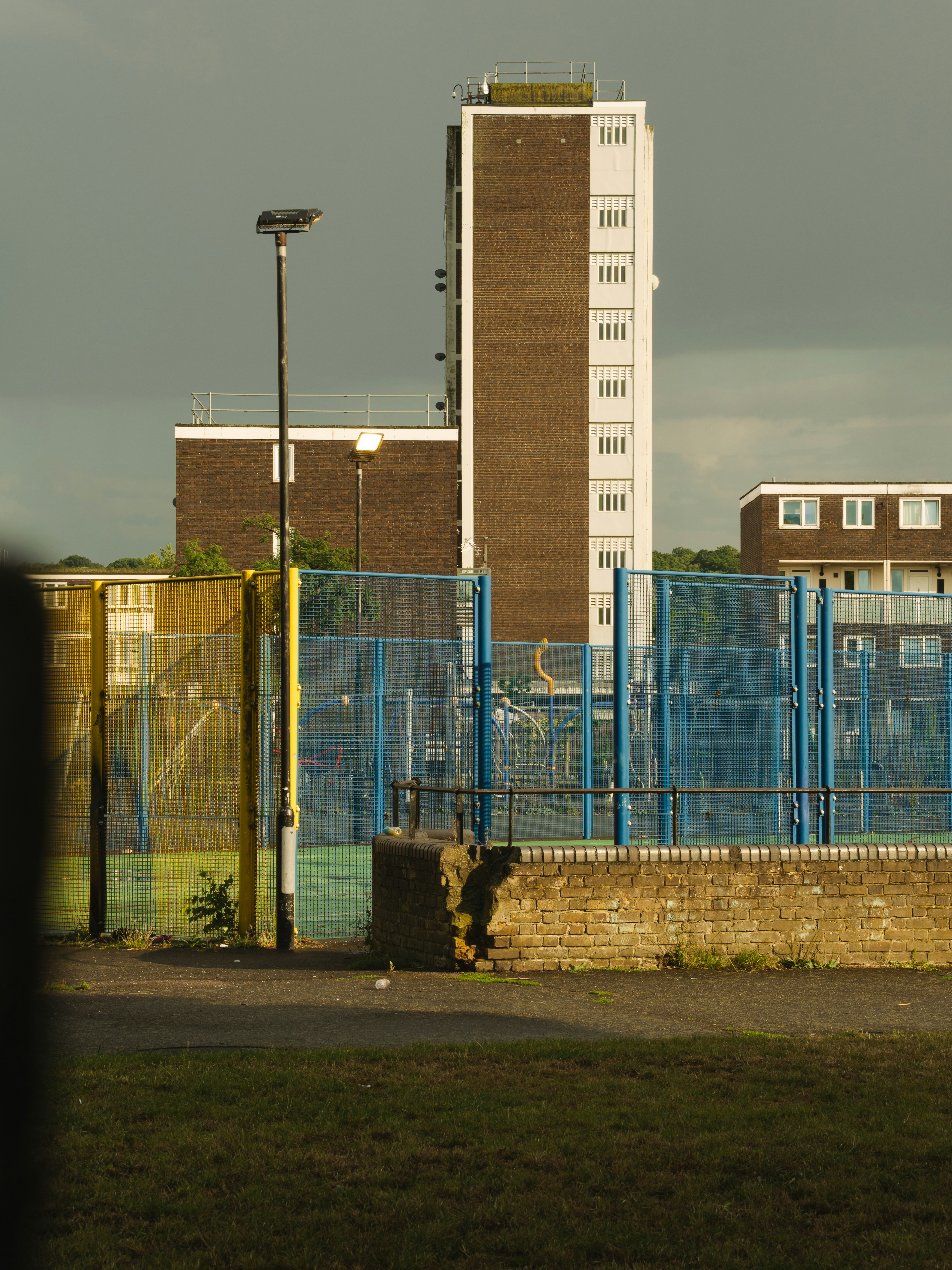 Tour d’habitation derrière une clôture de terrain de jeu.